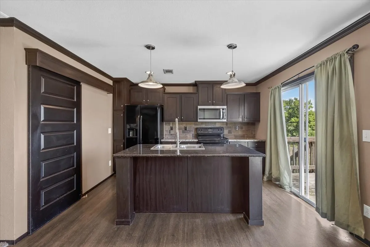 Another view of the kitchen showing the barn door leading into the pantry