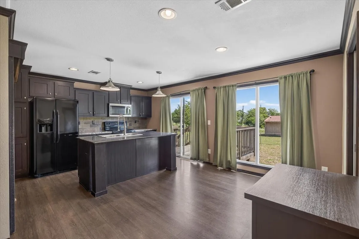 Kitchen with granite counter tops, stainless style appliance and a breakfast bar.