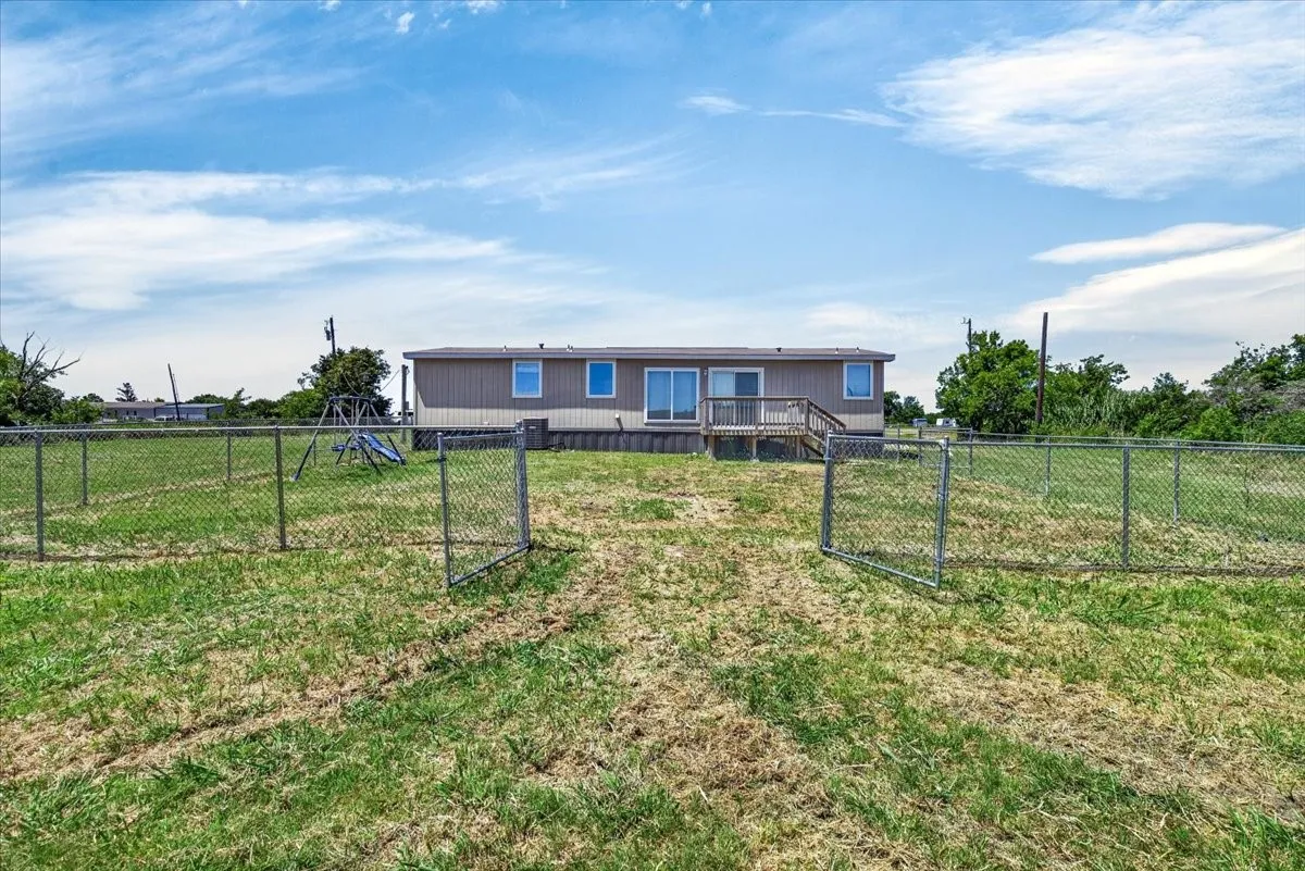 open back porch, backyard is partially fenced with chain link fencing