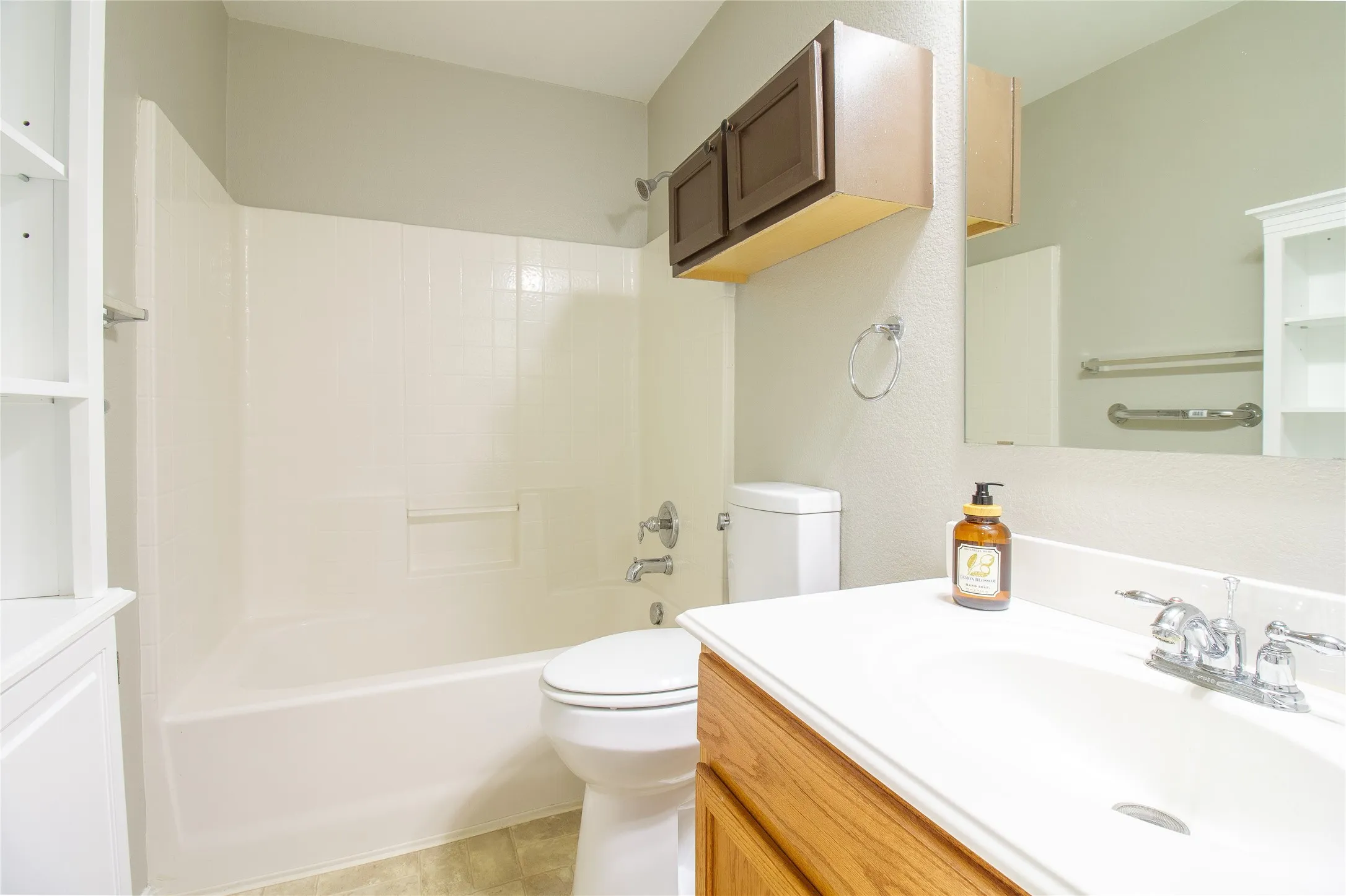 Bathroom featuring a white bathtub, toilet, and vanity with an integrated sink