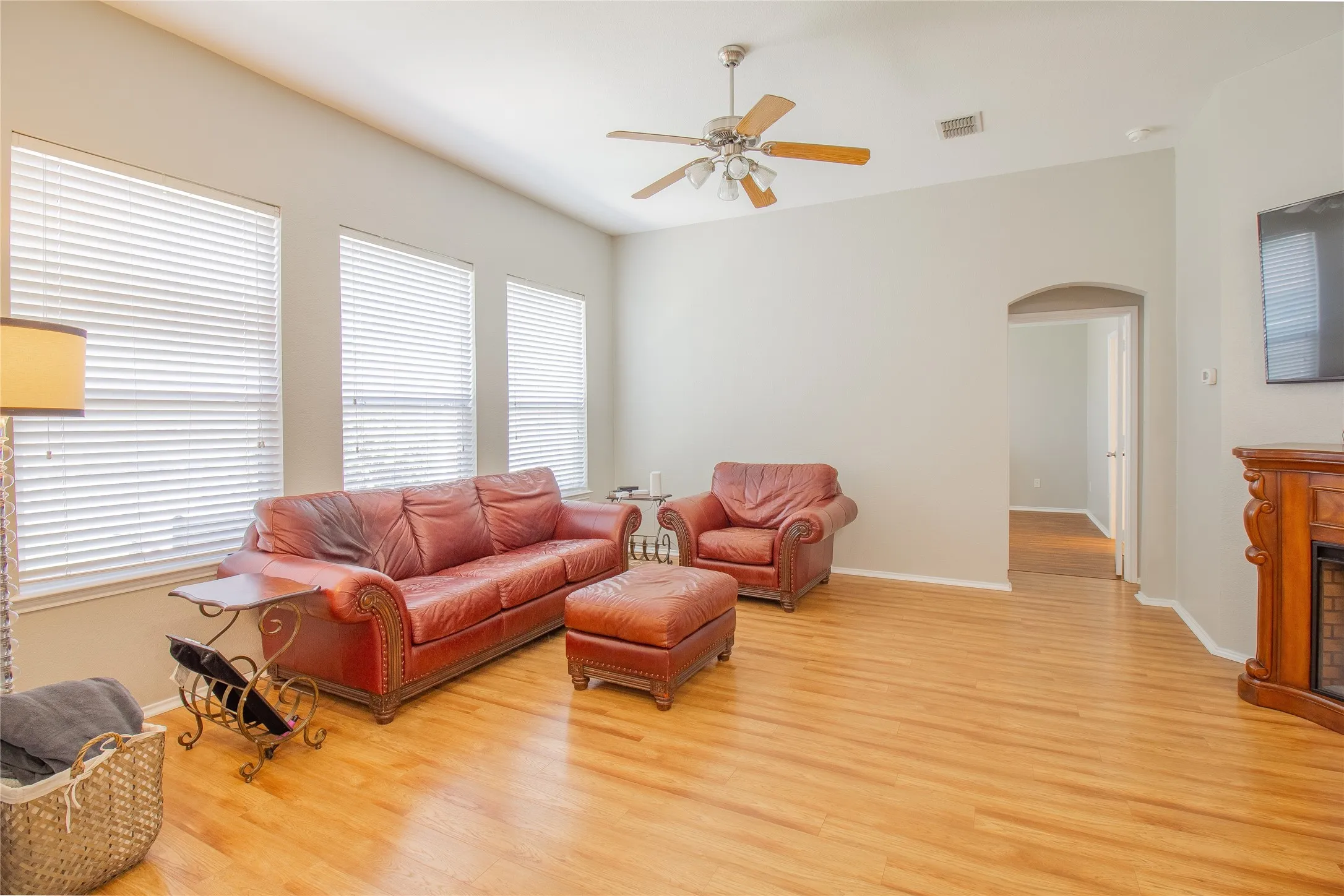 Living area featuring wood-finish flooring, vaulted ceiling, and an arched doorway
