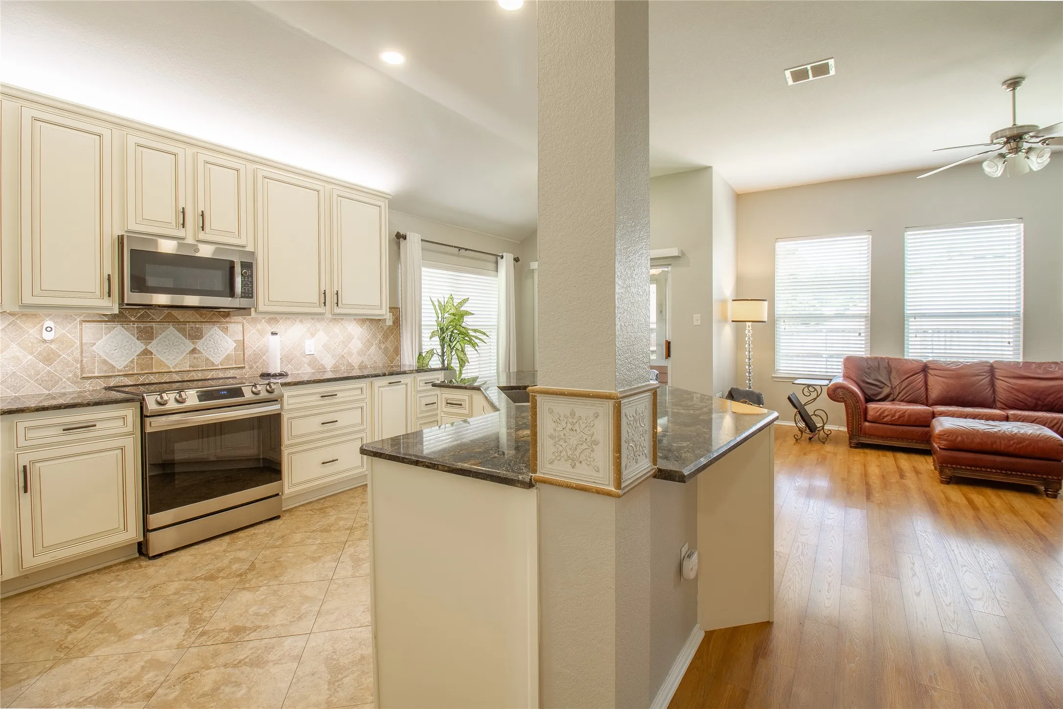 Kitchen with cream-finished cabinetry, stainless steel appliances, and granite countertops