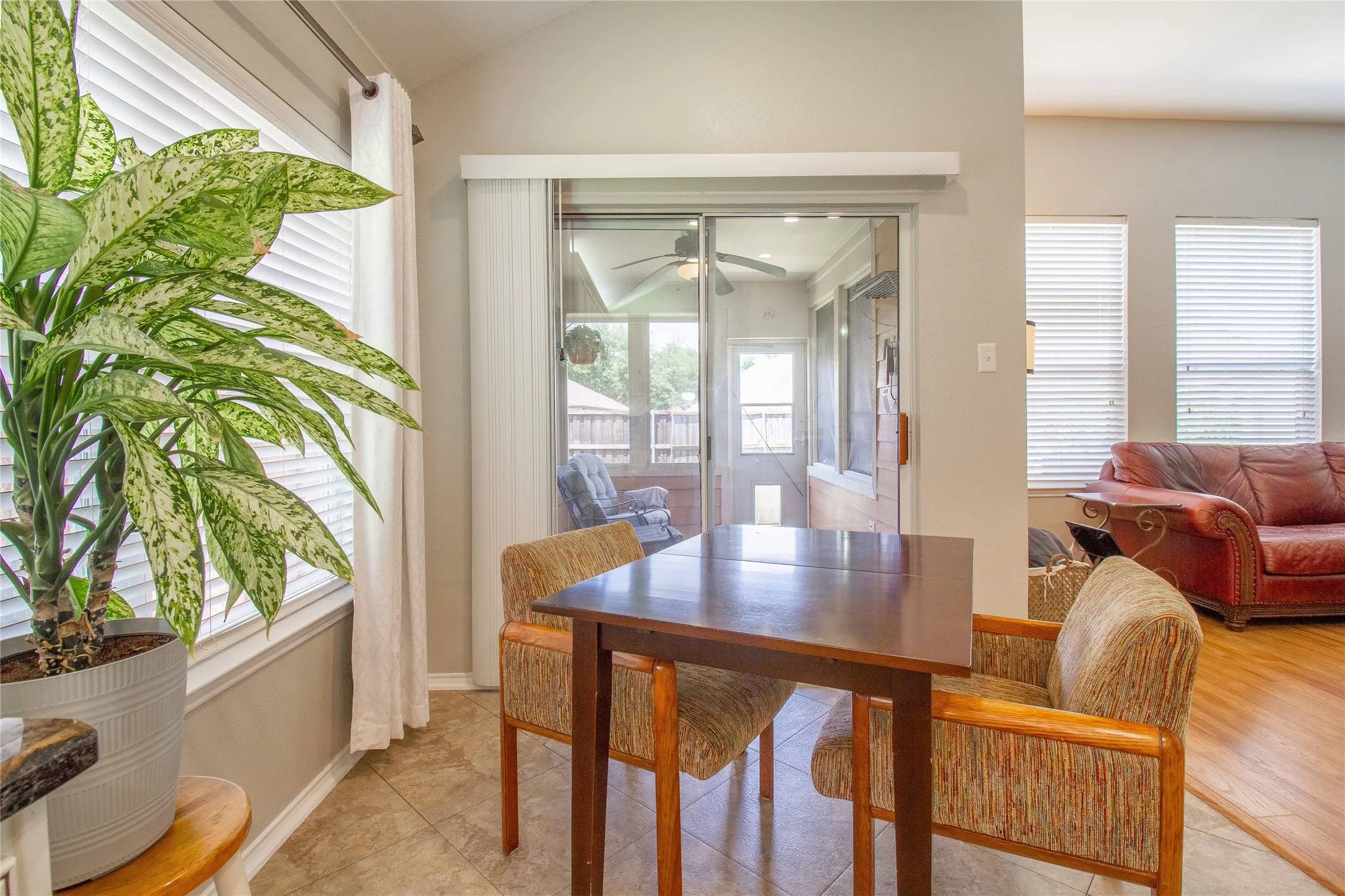 Tiled flooring in a dining area featuring a sliding glass door leading to a screened porch