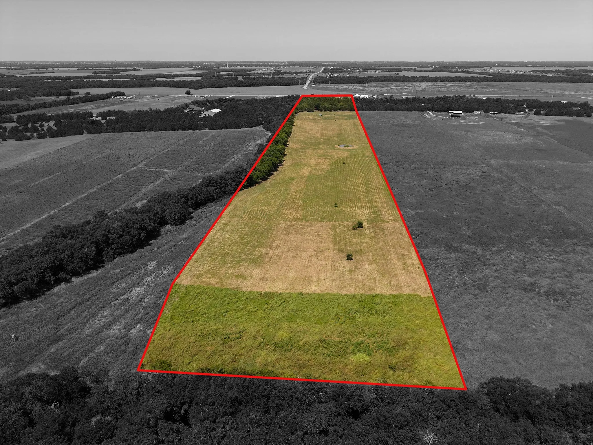 Expansive land parcel featuring open fields and tree lines