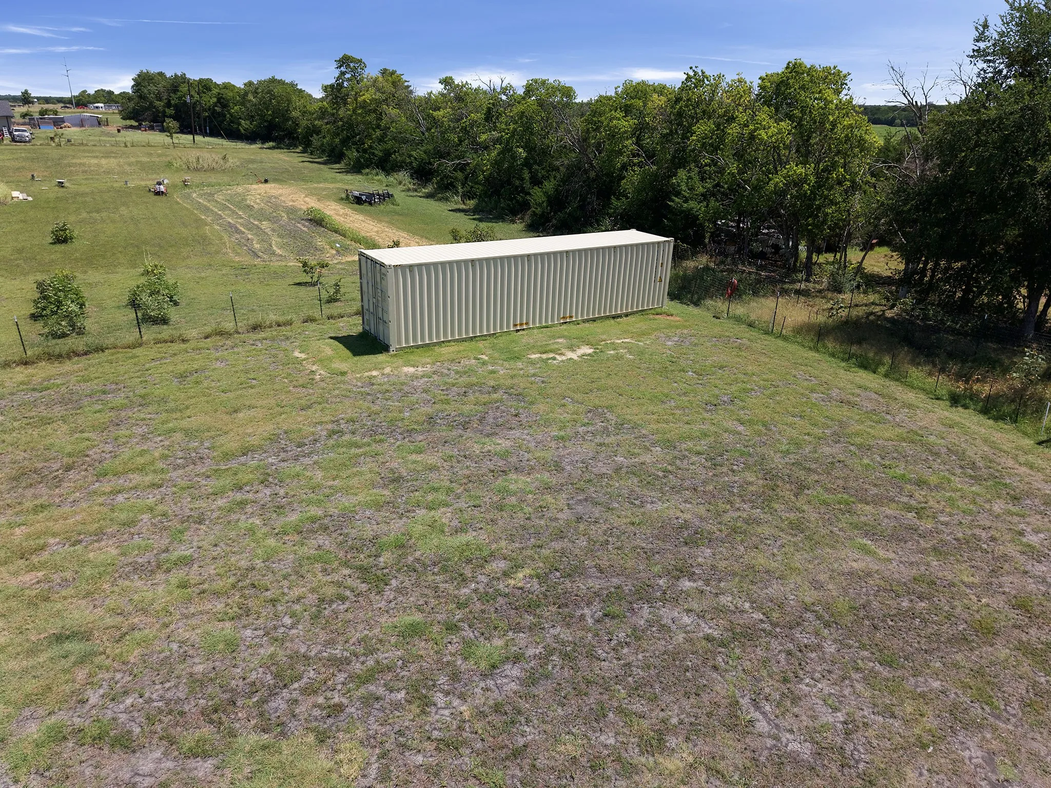 Expansive outdoor space featuring a corrugated metal storage container on a grassy mound
