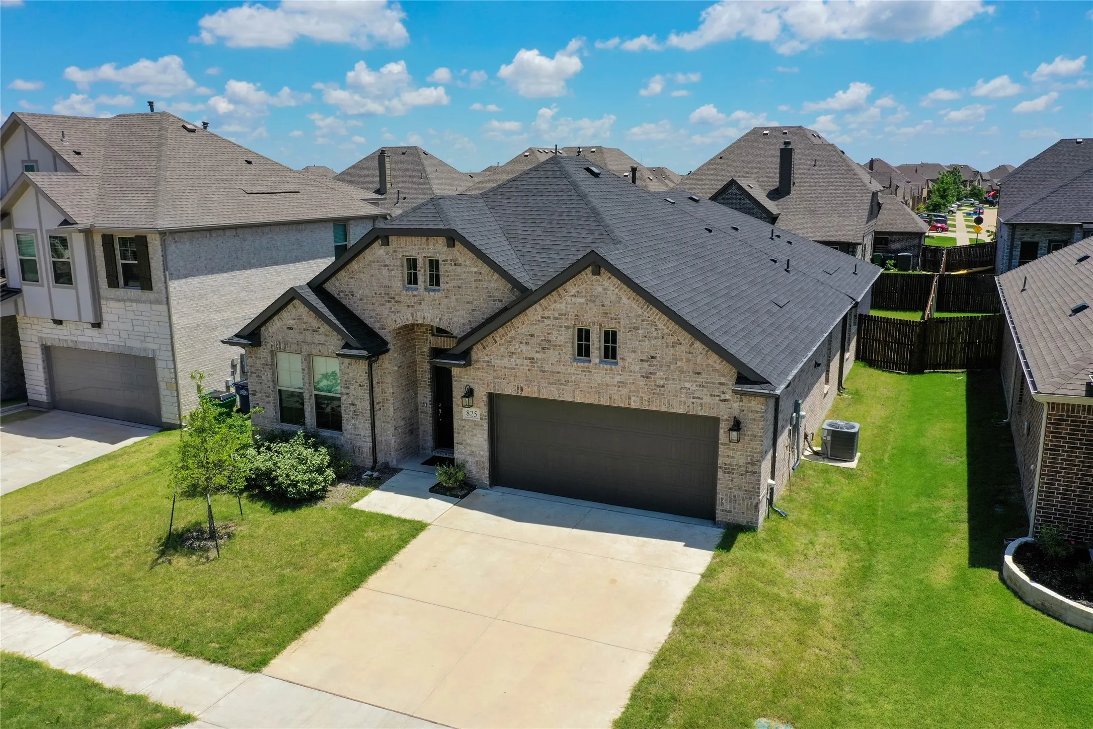 Brick and stone exterior with a dark shingled roof