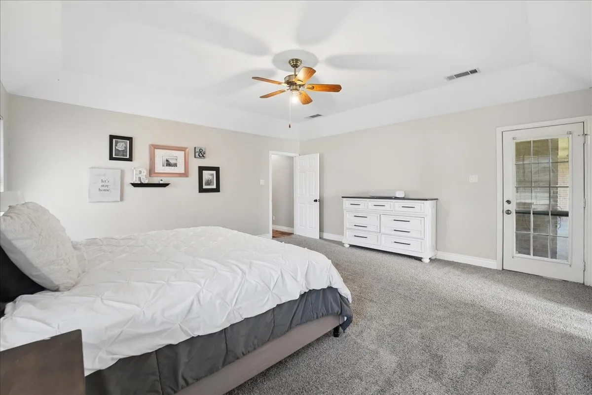 Spacious room featuring vaulted ceilings, light gray wall paint, and gray carpet flooring