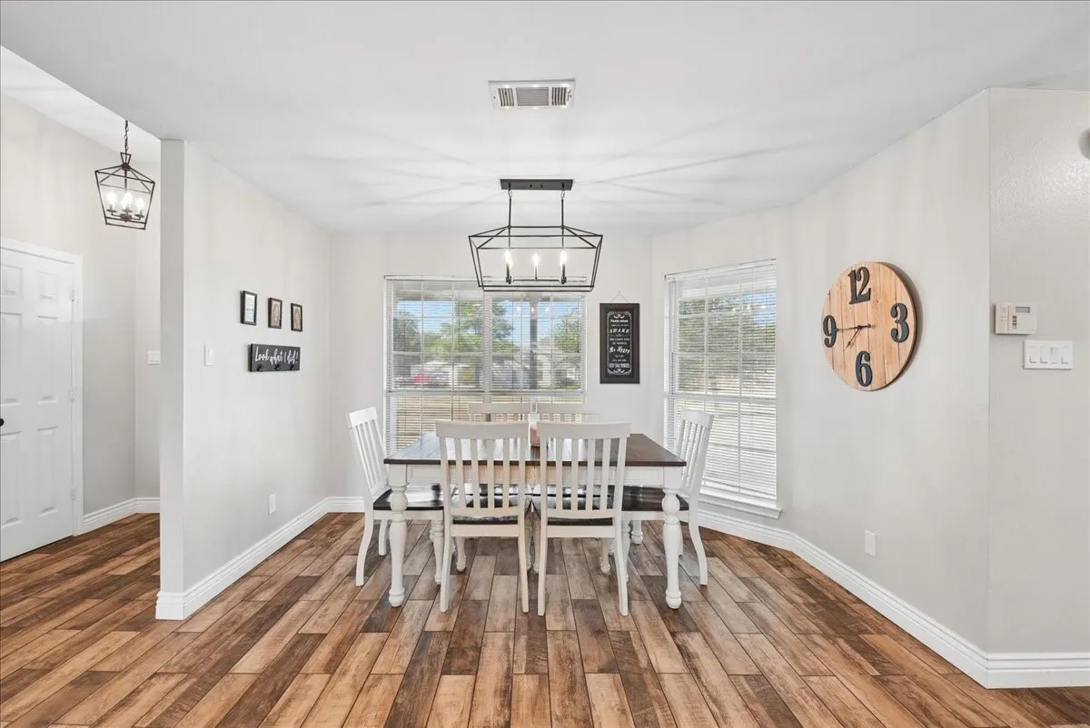Dining space featuring wood-finish flooring, white baseboards, and light gray walls