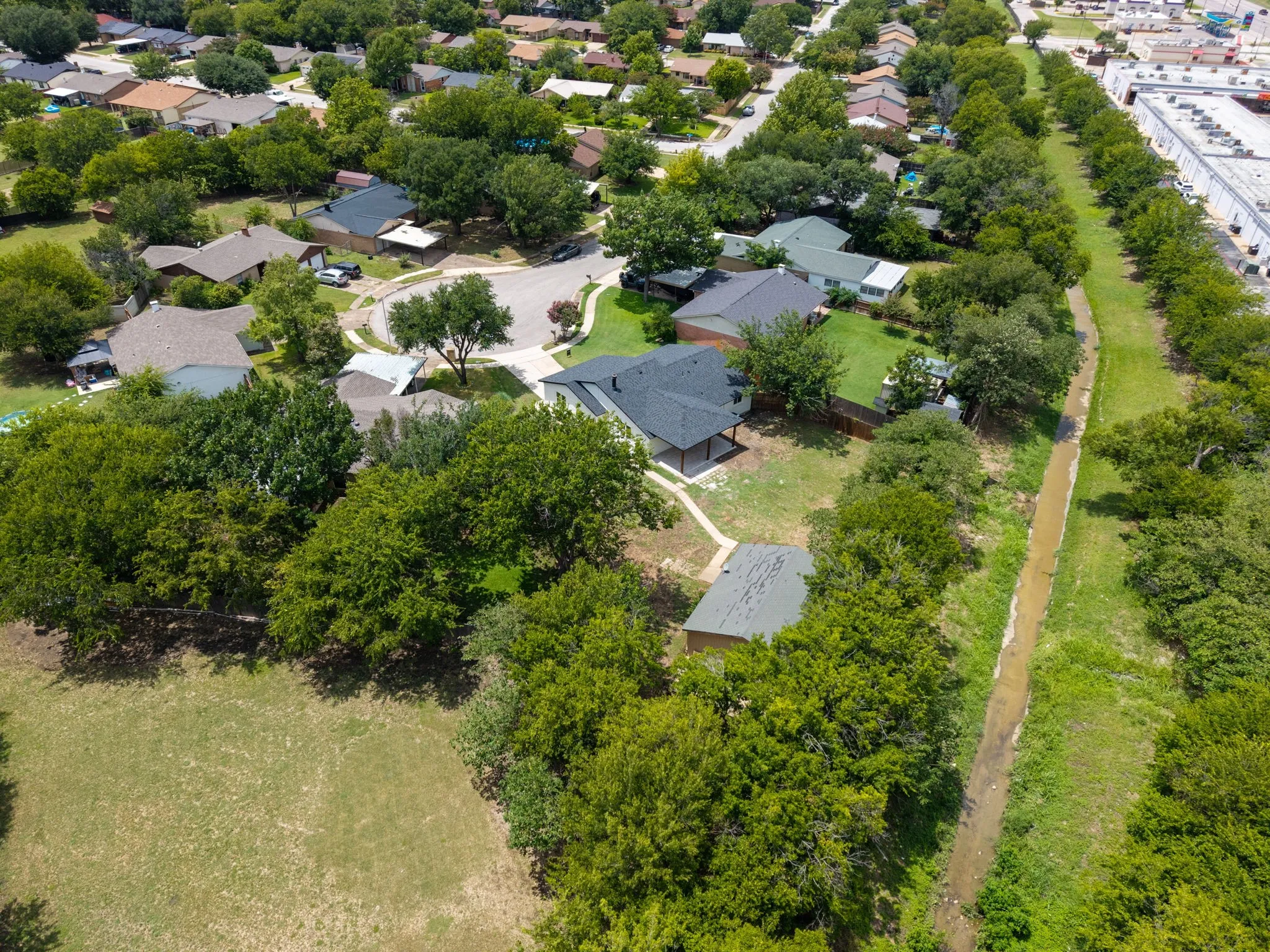 Aerial property perspective showcasing a residential area with mature trees
