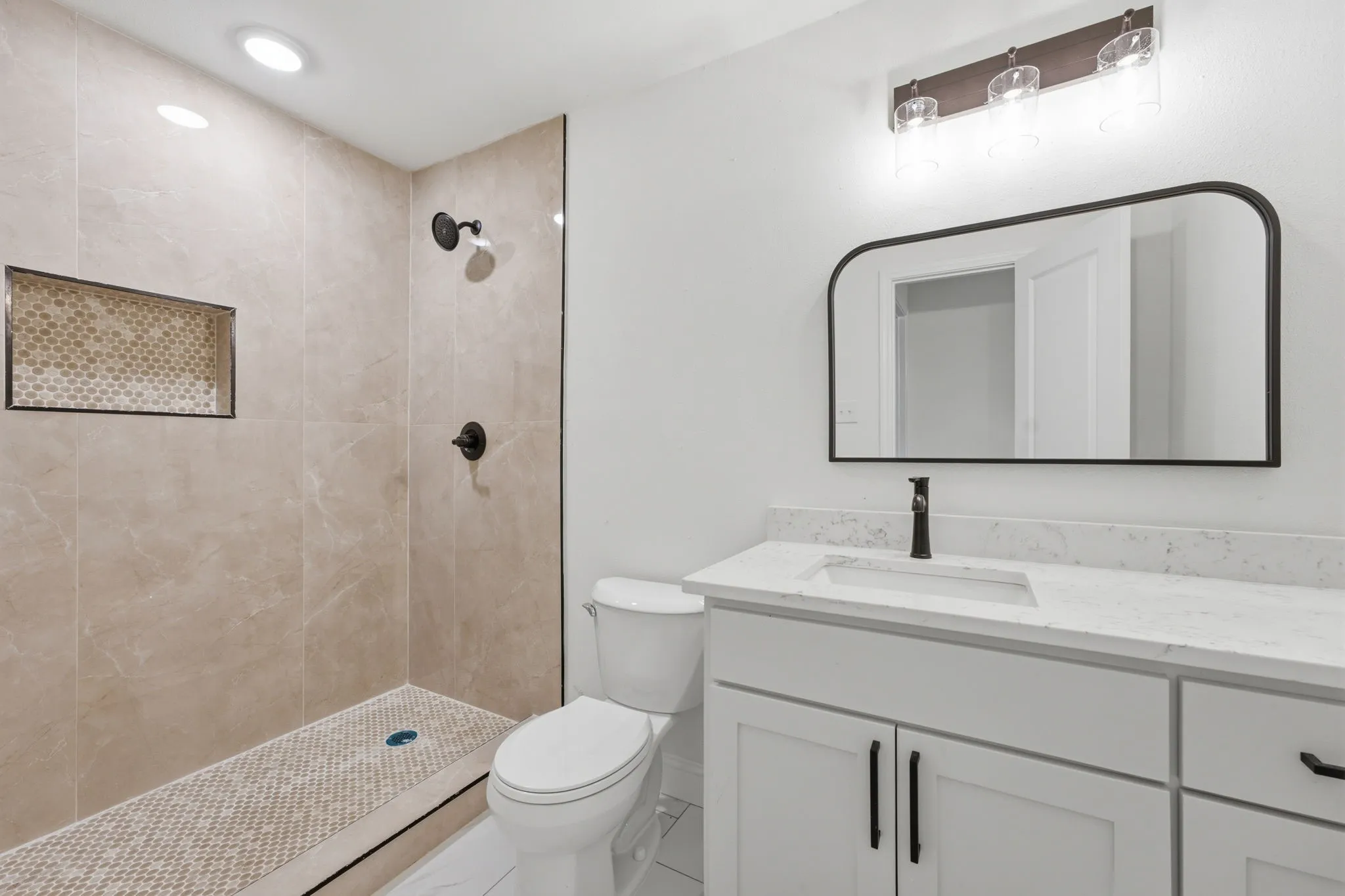 Shower with recessed niche featuring tile surround and mosaic floor