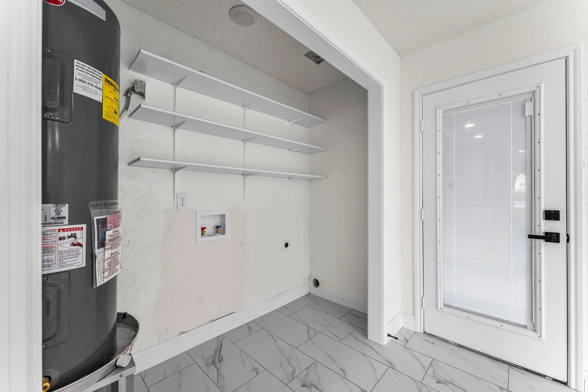 Utility area with white shelving units and a water heater