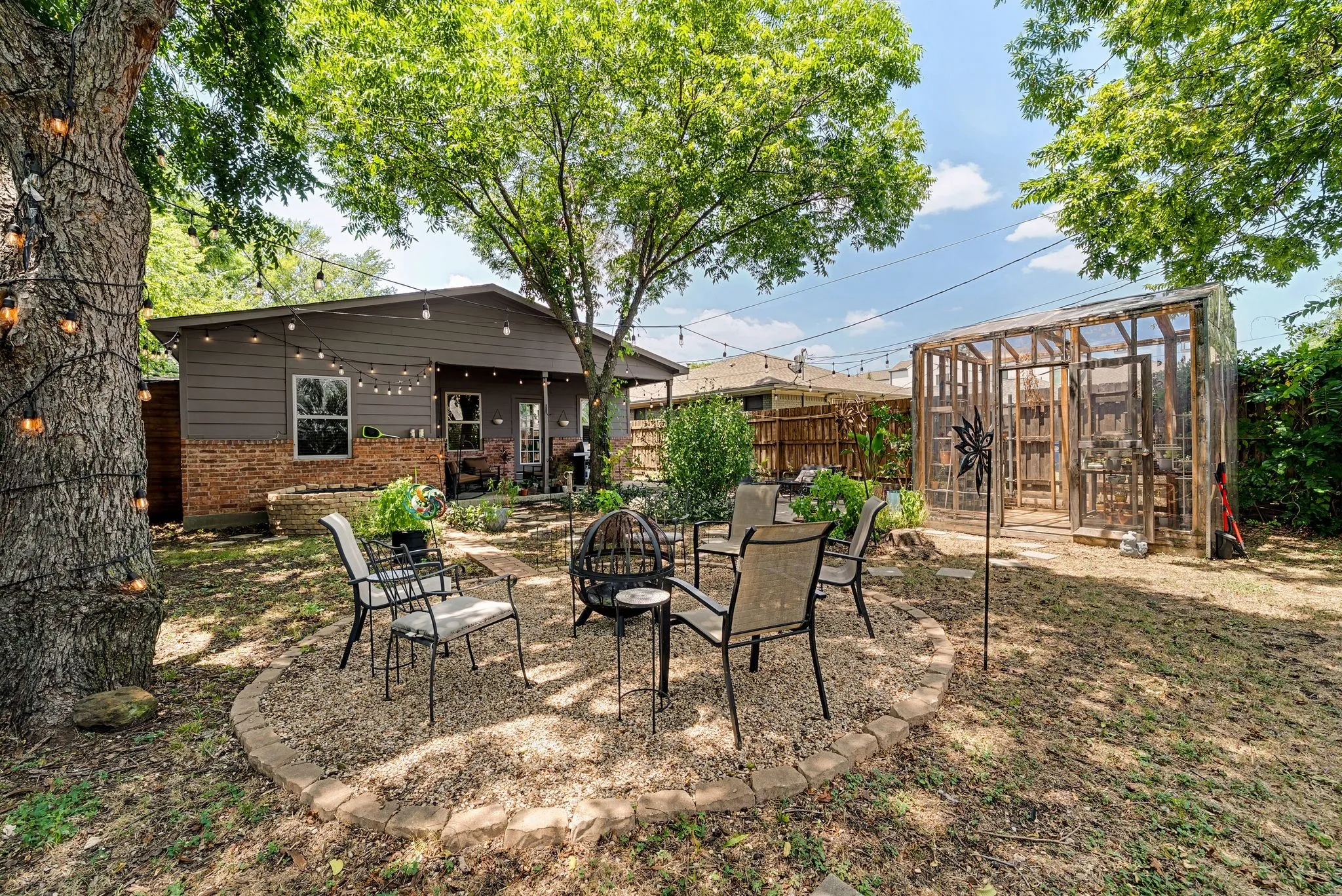 Private backyard featuring a circular gravel patio defined by a brick border