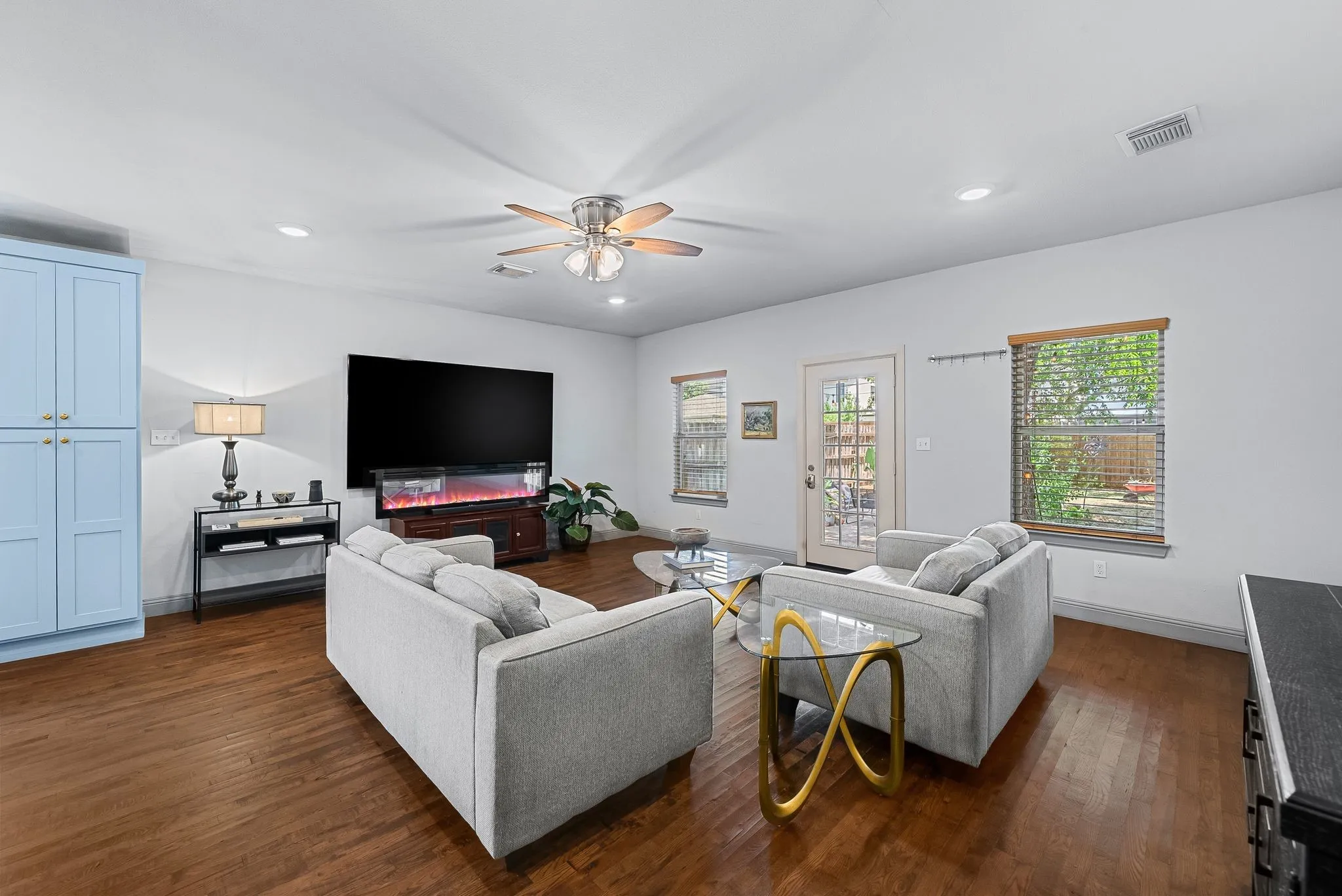 Open-concept living area with wood-finish flooring, recessed lighting, and a ceiling fan