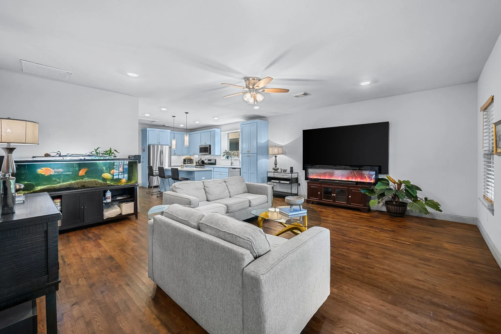 Open-concept living space featuring wood-finish flooring, recessed lighting, and a ceiling fan