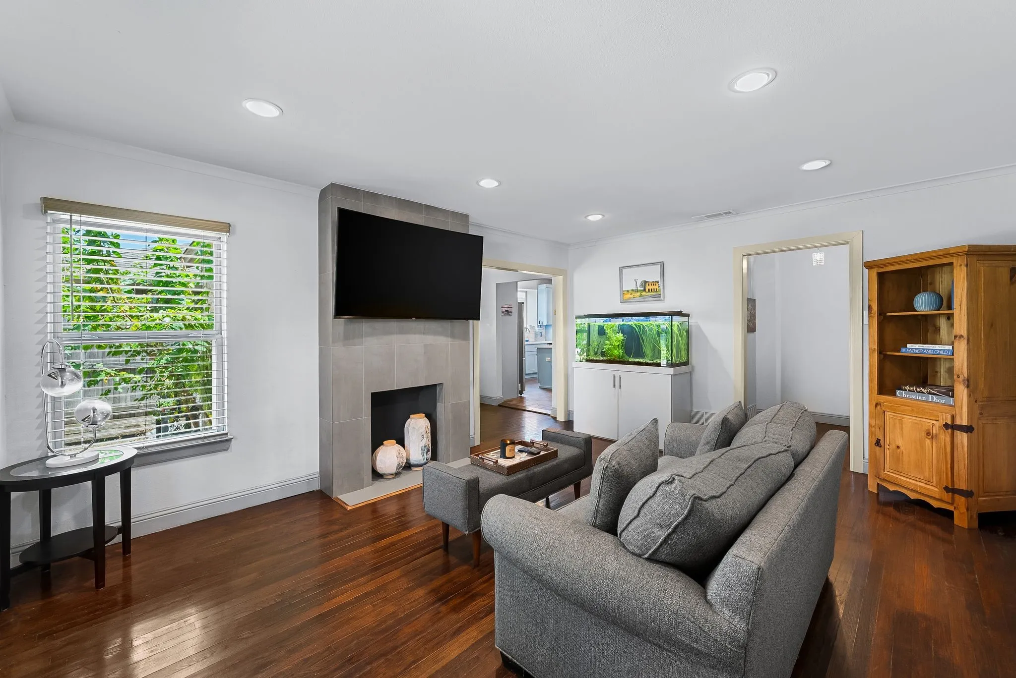 Living area featuring rich wood-finish flooring and recessed lighting