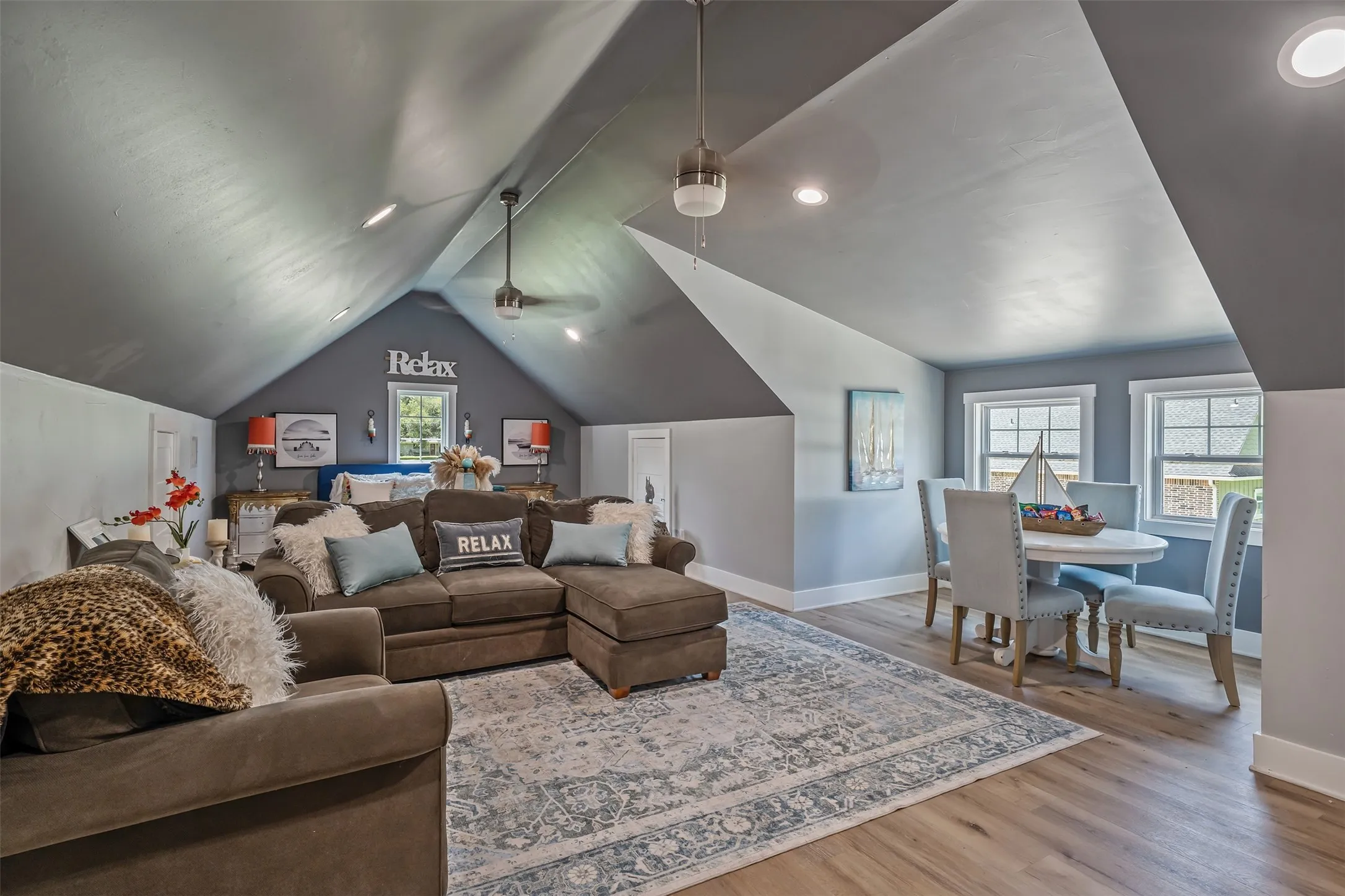 Vaulted ceiling room featuring wood-finish flooring and recessed lighting