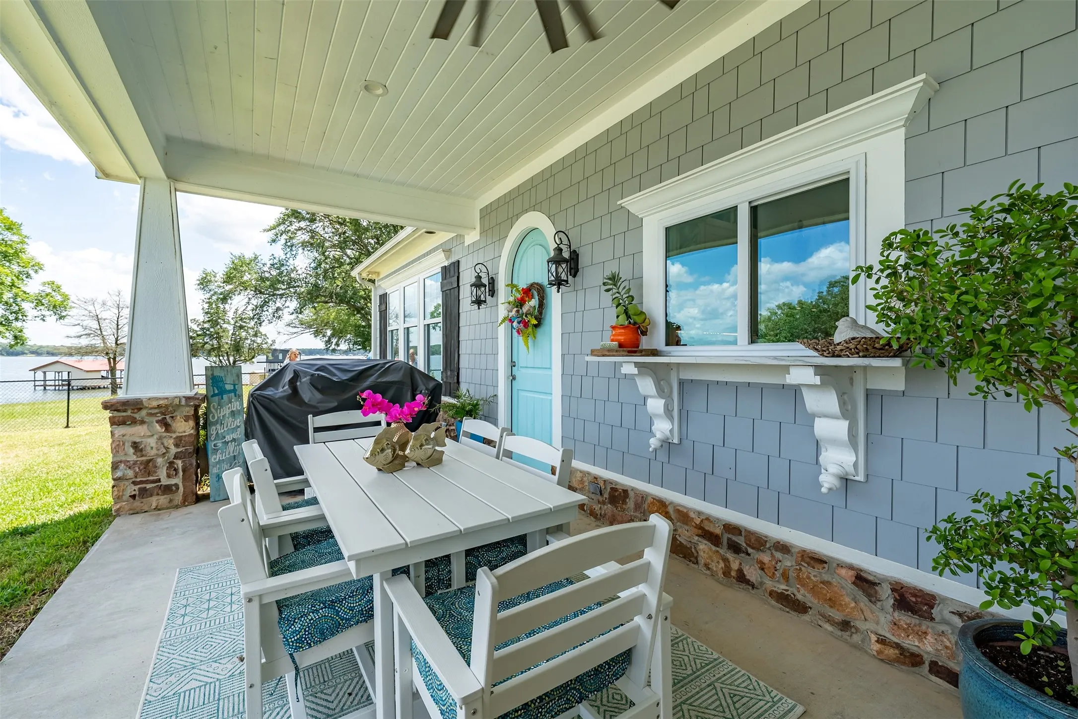 Covered porch featuring a beadboard ceiling and stone-clad column base
