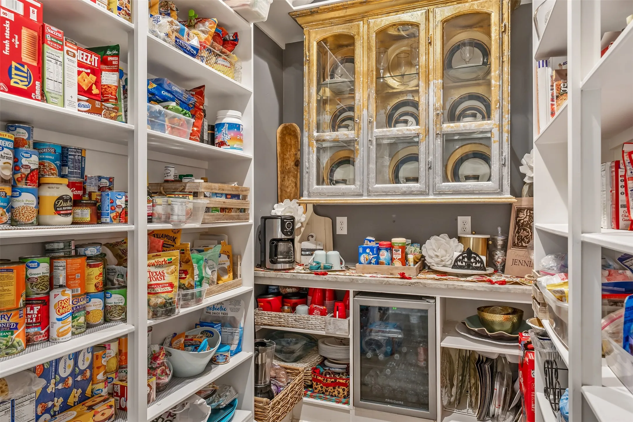 Spacious pantry featuring extensive built-in shelving, a dedicated counter space, and a built-in beverage cooler