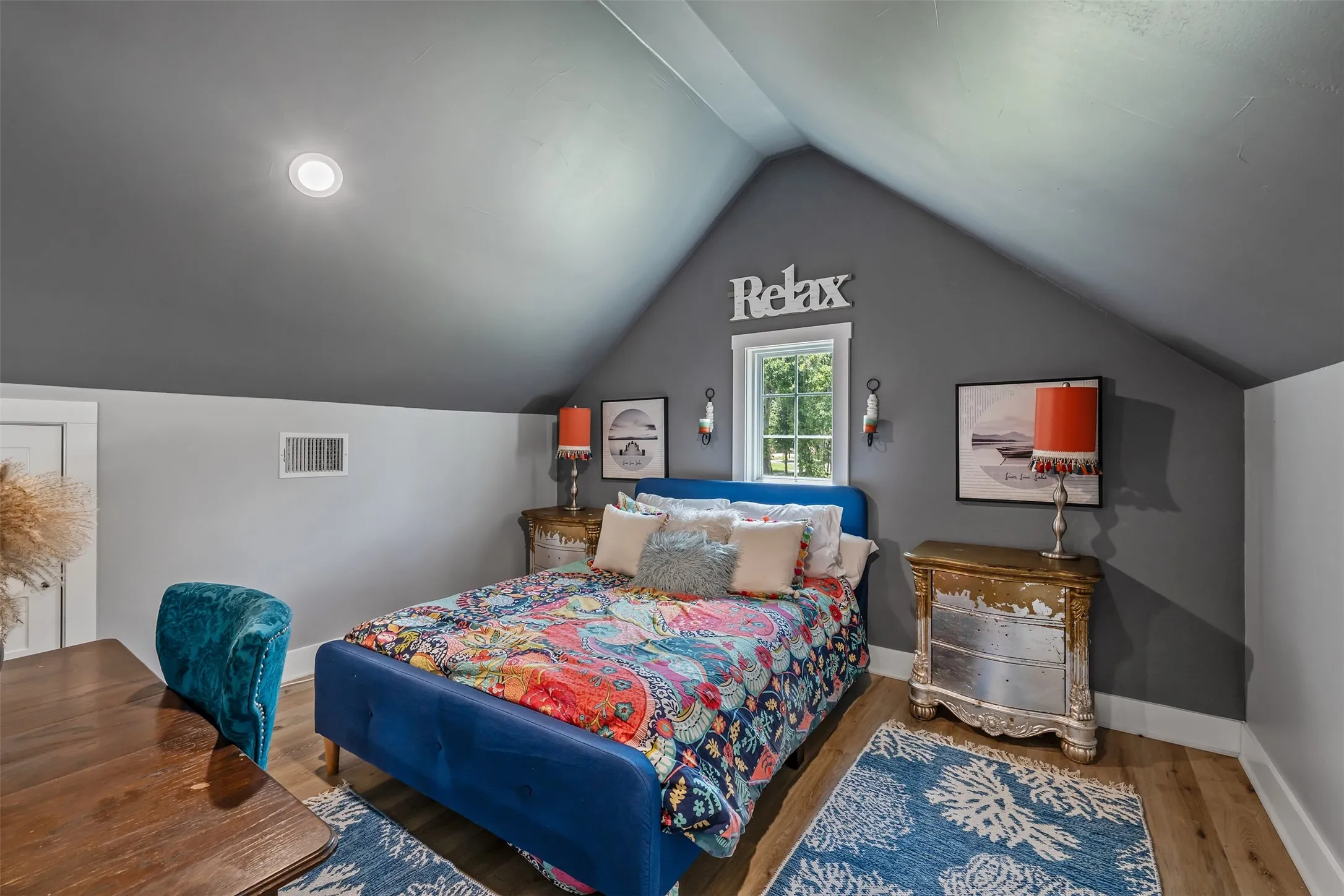Vaulted ceiling with recessed lighting, wood-finish flooring, white trim, and a window with natural light