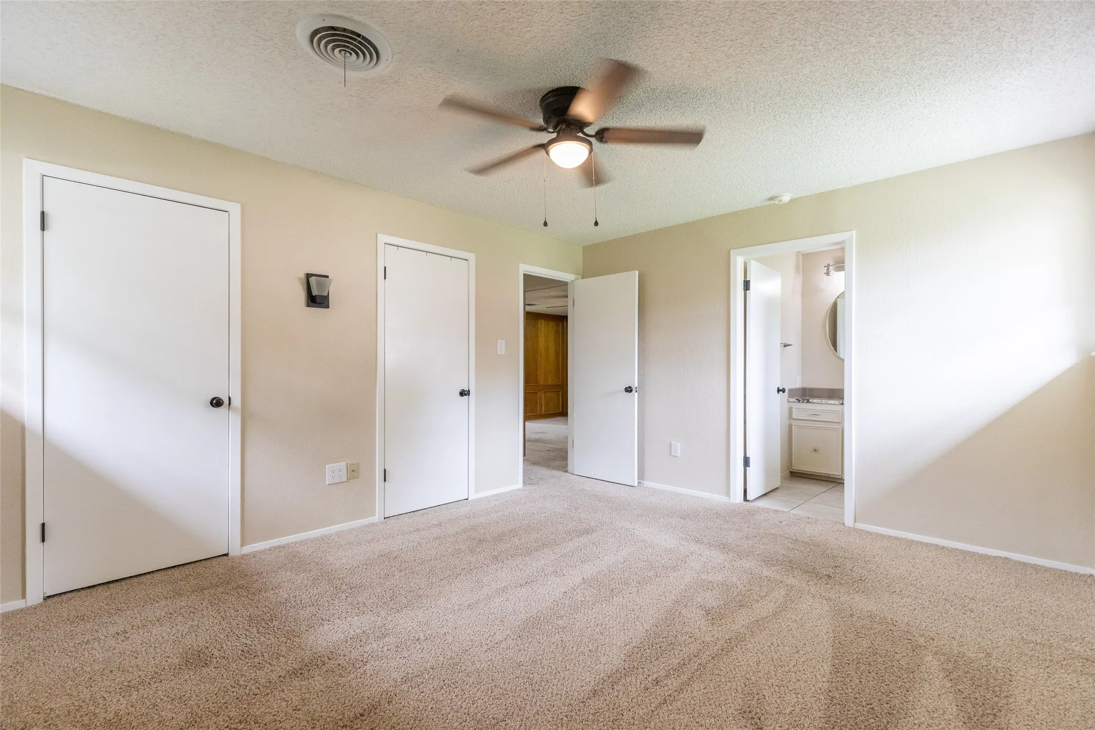 Carpeted interior room featuring a ceiling fan with integrated lighting