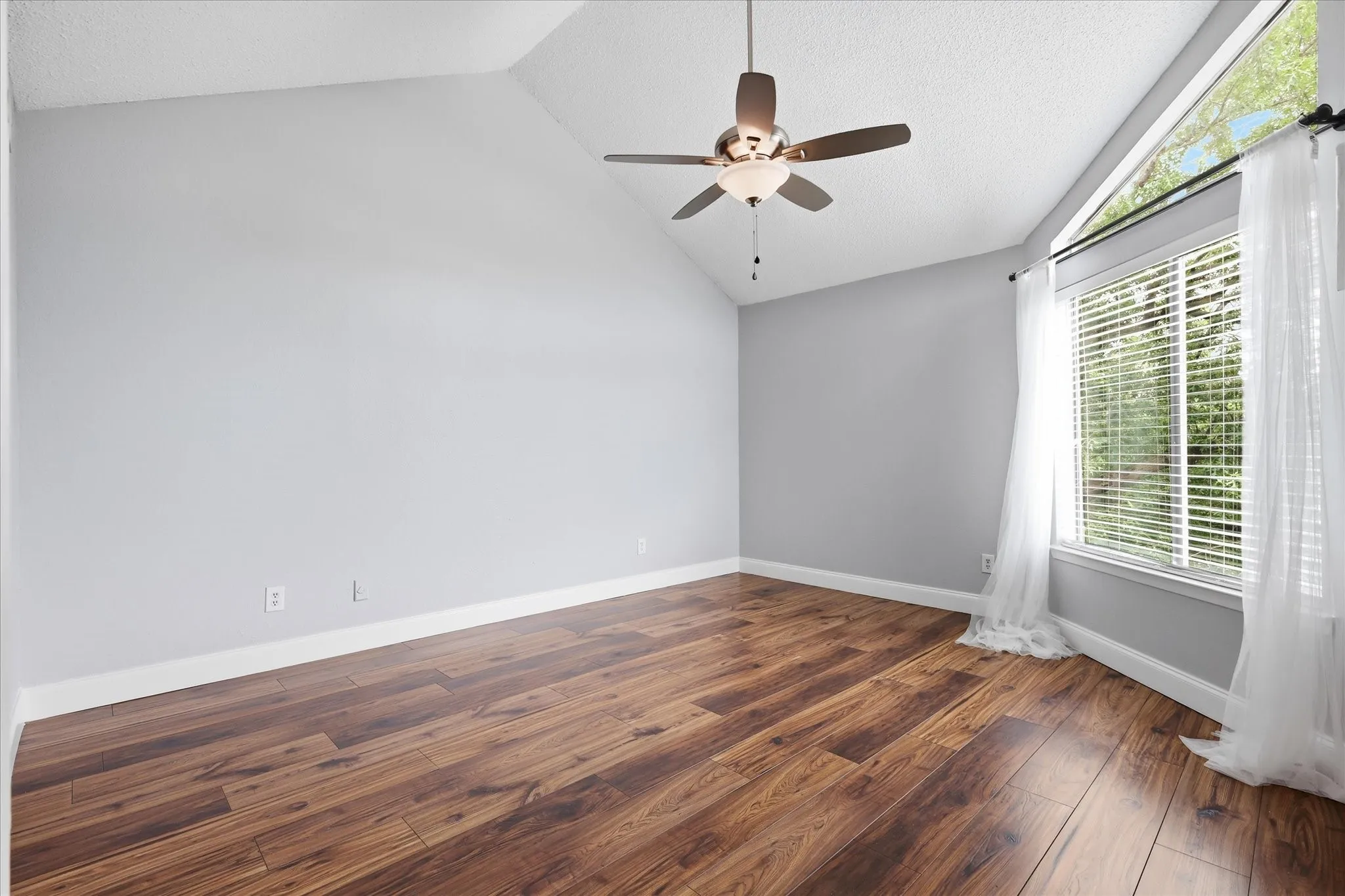 Vaulted ceilings featuring a ceiling fan with integrated lighting