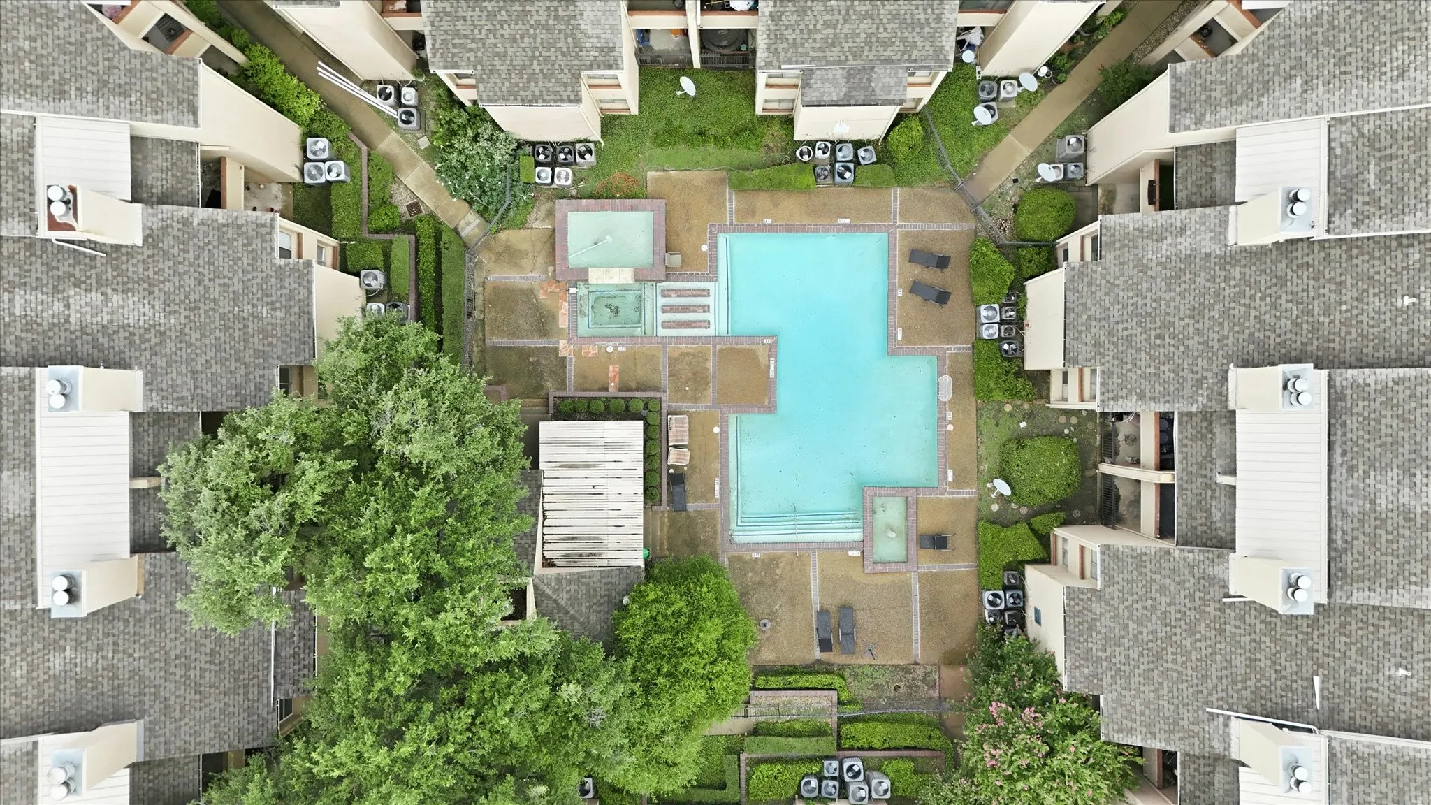 Central courtyard featuring a rectangular pool, a separate spa, and surrounding paved patio areas