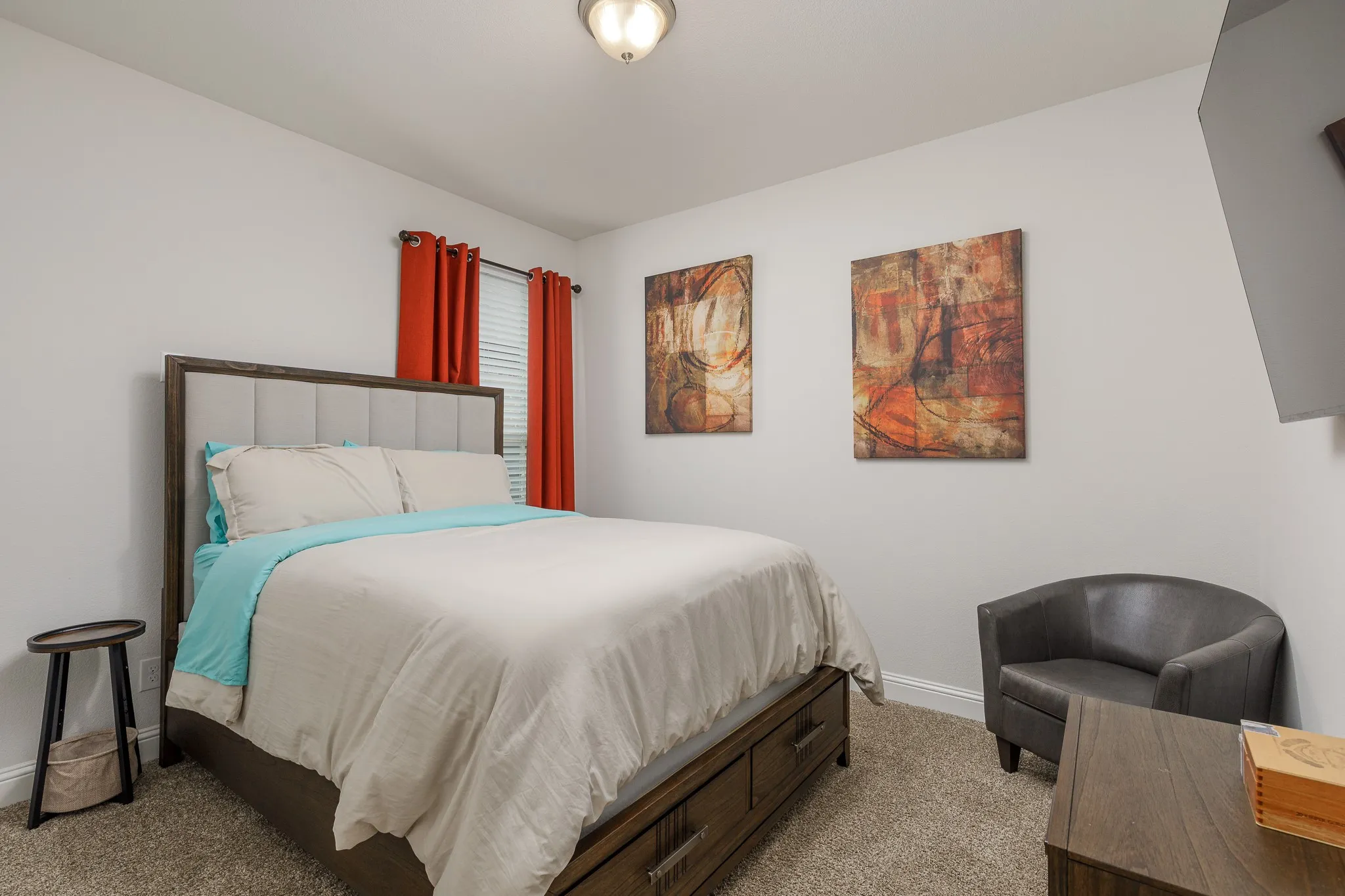 Bedroom featuring light neutral wall paint, carpet flooring, a window with blinds, and an upholstered headboard