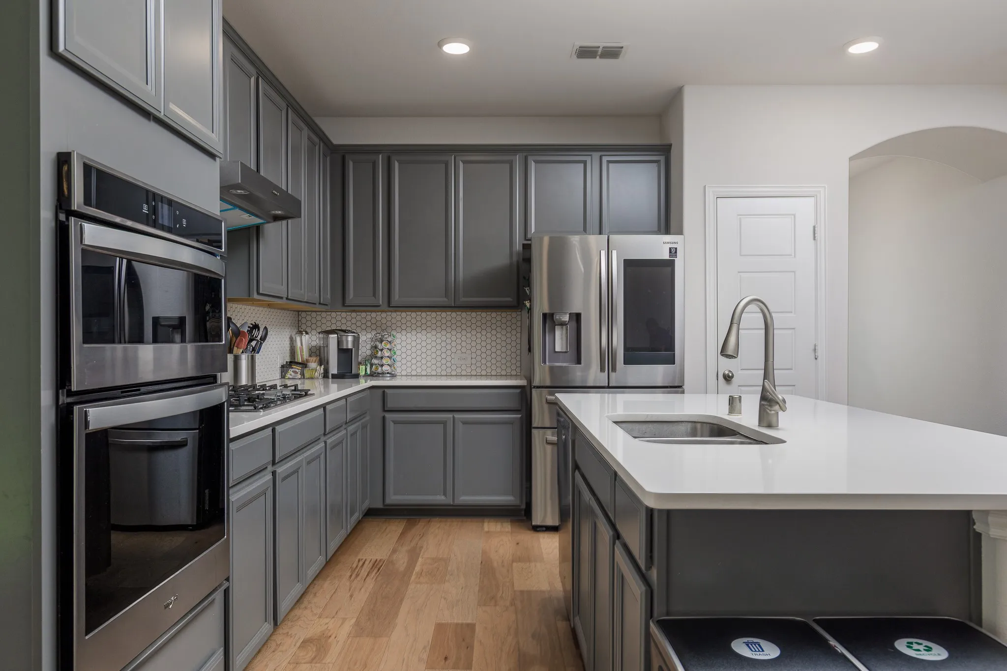 Modern kitchen featuring light wood-finish flooring and recessed lighting