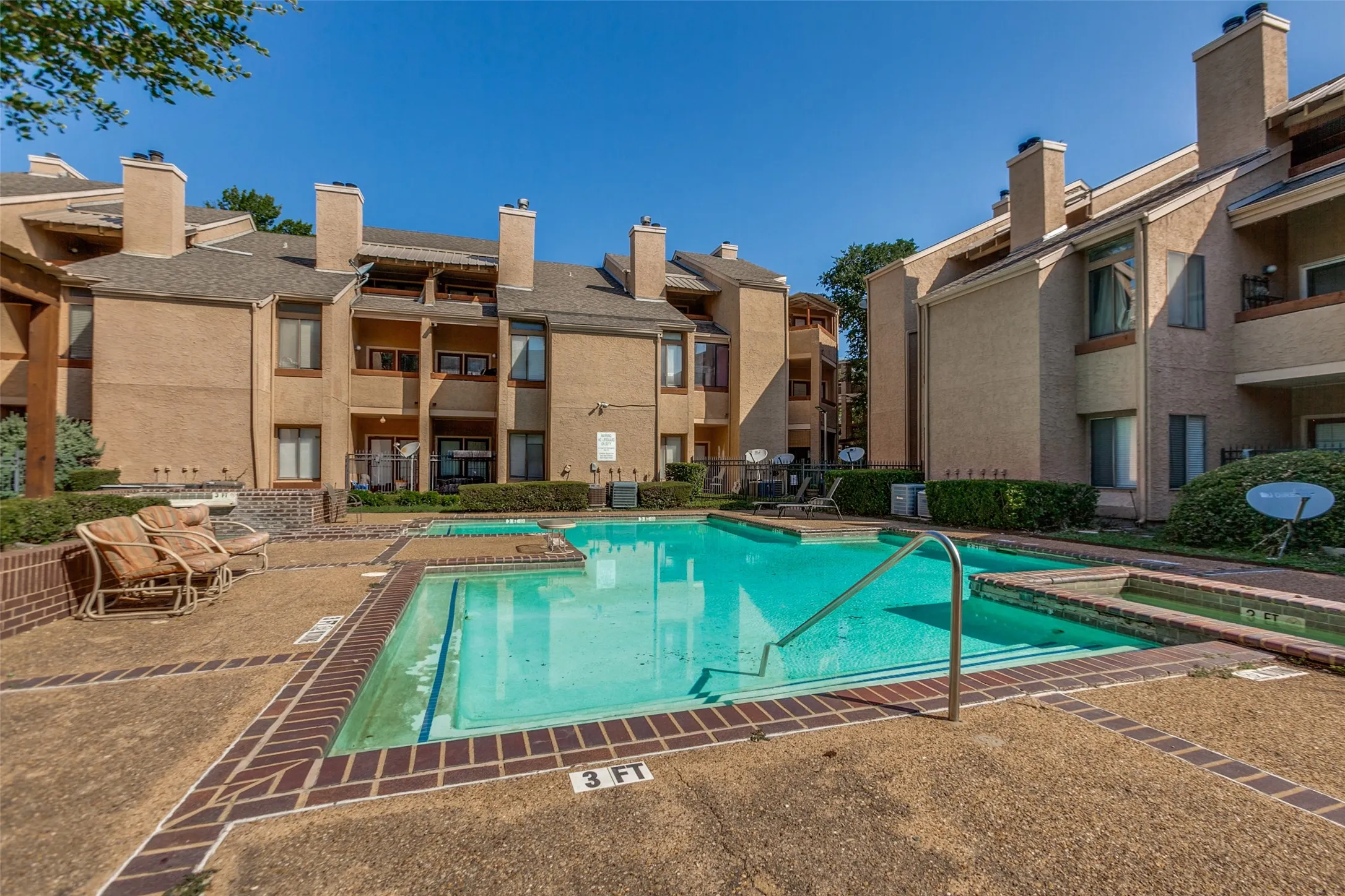 Outdoor swimming pool with integrated spa and surrounding concrete patio