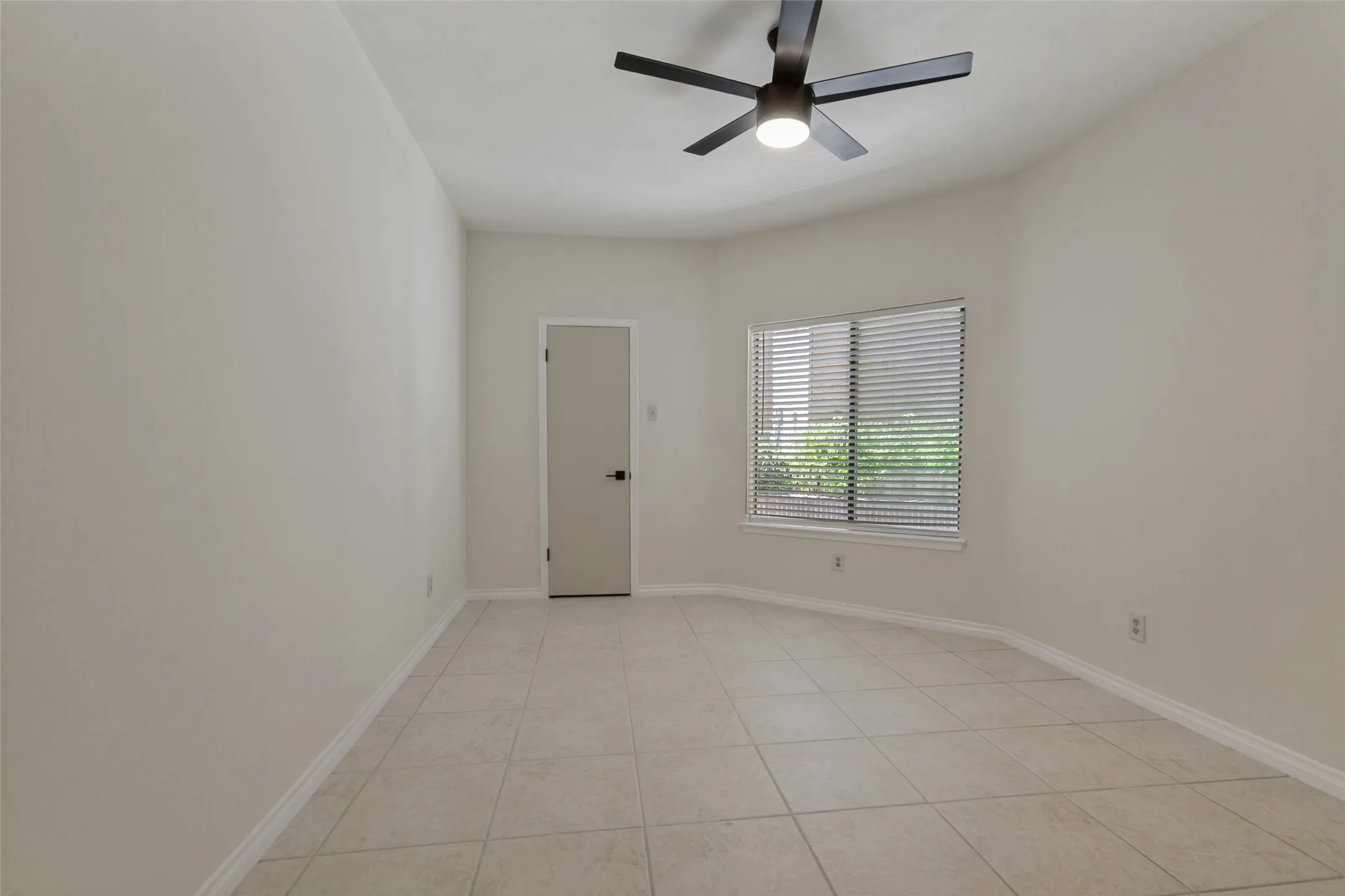 Room featuring light-toned tile flooring, neutral wall paint, and white baseboards