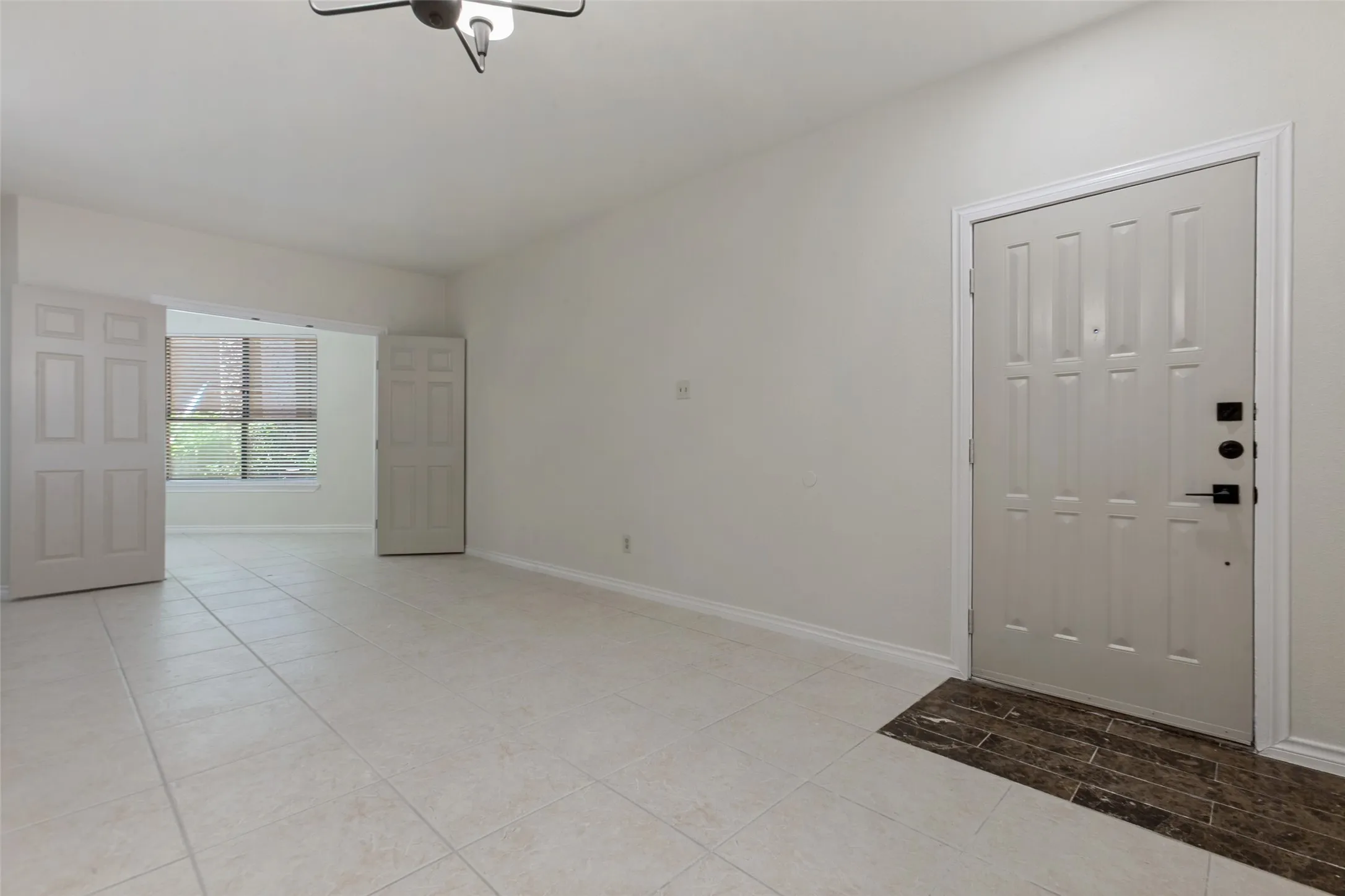 Spacious entry area with light-toned tile flooring throughout