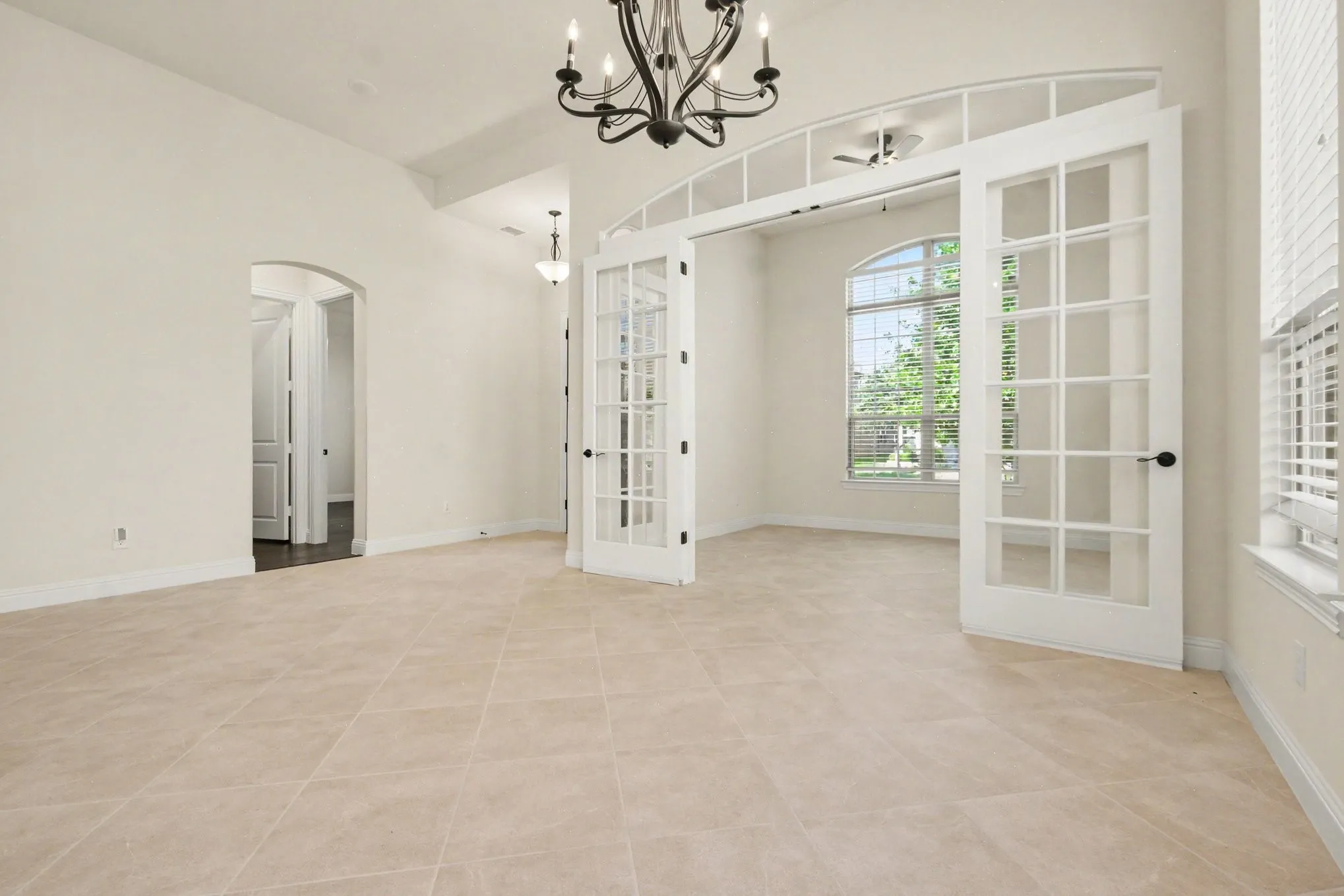 Dining Area leading to Study w French Doors.  Neutral paint throughout.