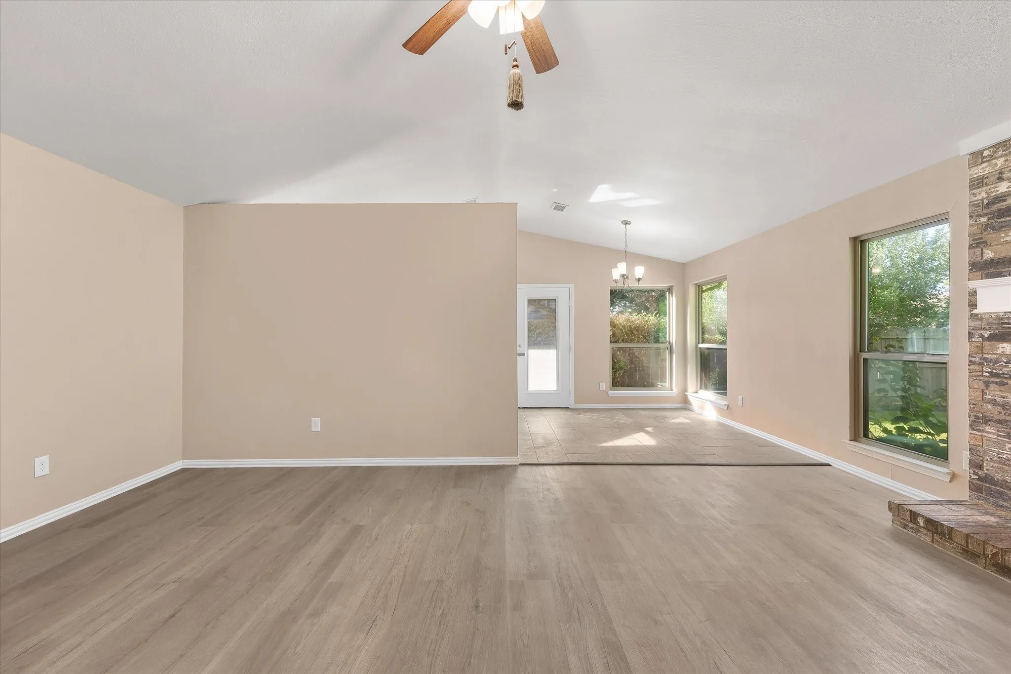 Large living room with eat in kitchen area in view.