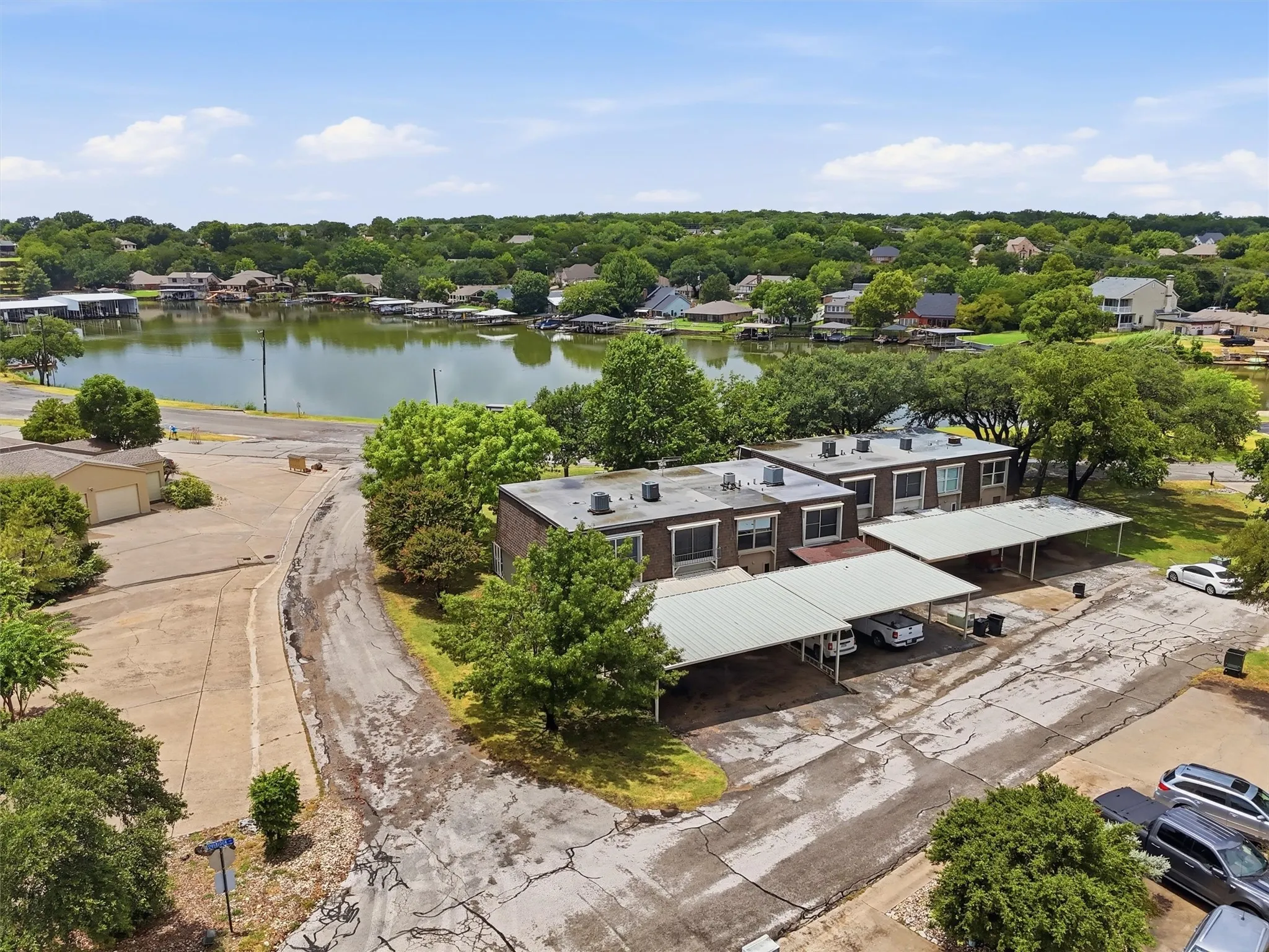 Multi-unit property featuring brick exteriors, multiple covered parking structures, and a waterside location