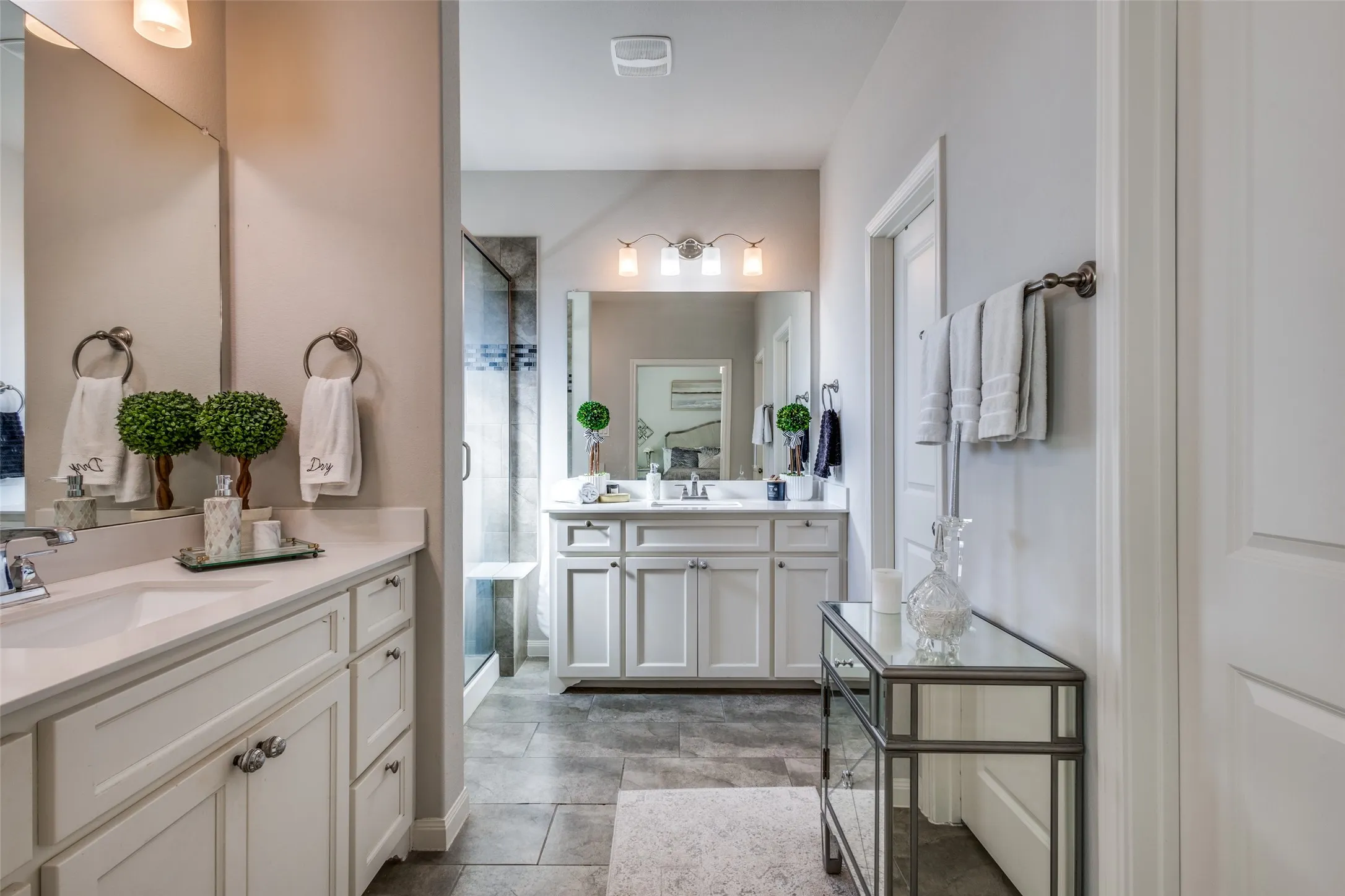 Double vanity featuring white shaker-style cabinetry, undermount sinks, and light-toned countertops