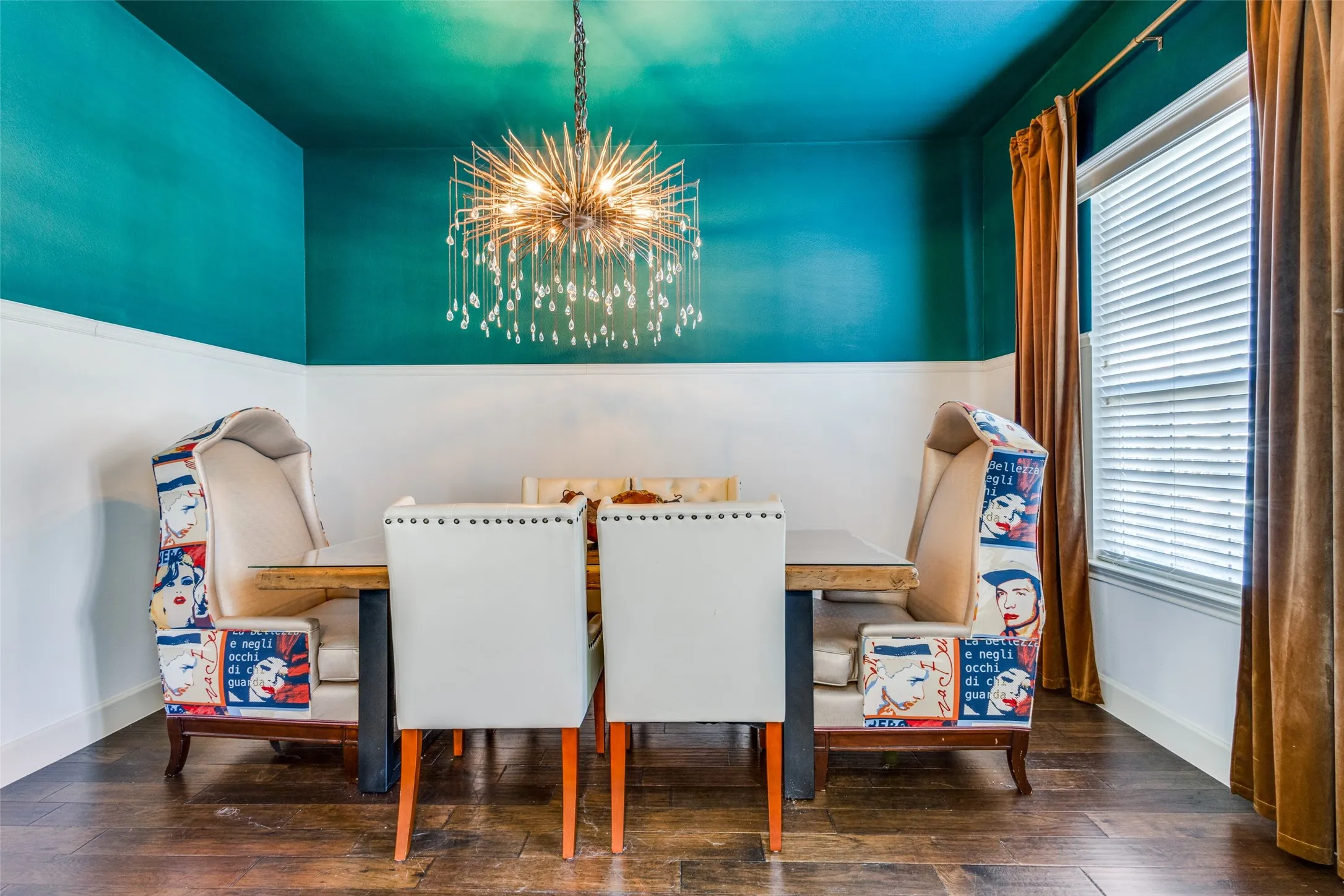Dining area featuring wood-finish flooring, a contemporary chandelier, two-tone wall treatment, and a window with blinds