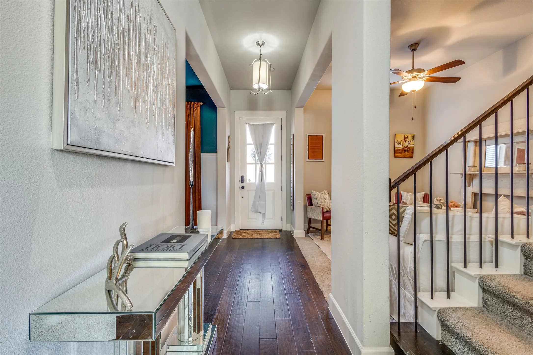 Entryway featuring dark wood-finish flooring, a white paneled door with window inserts, and a decorative overhead light fixture
