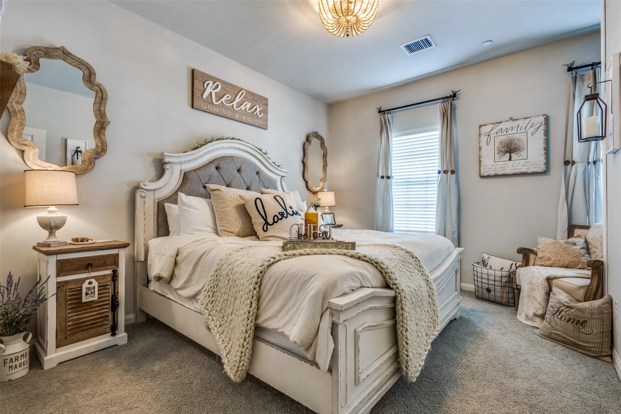 Carpeted bedroom featuring a decorative chandelier and dual windows with blinds