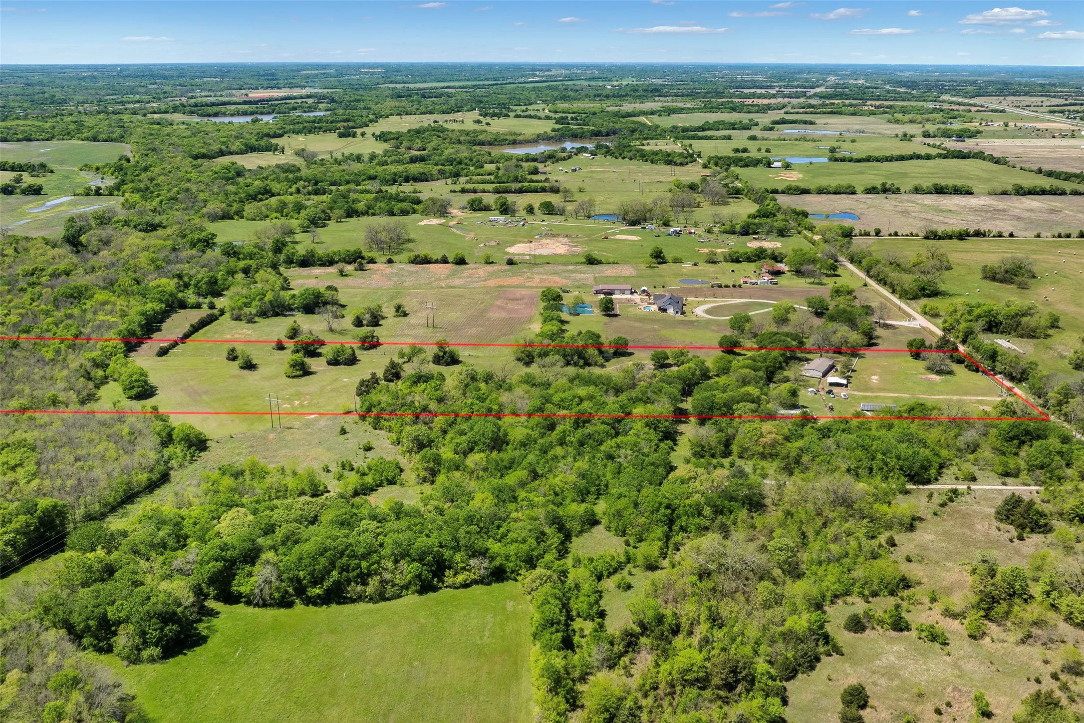 Expansive rural property featuring a mix of open land and mature trees
