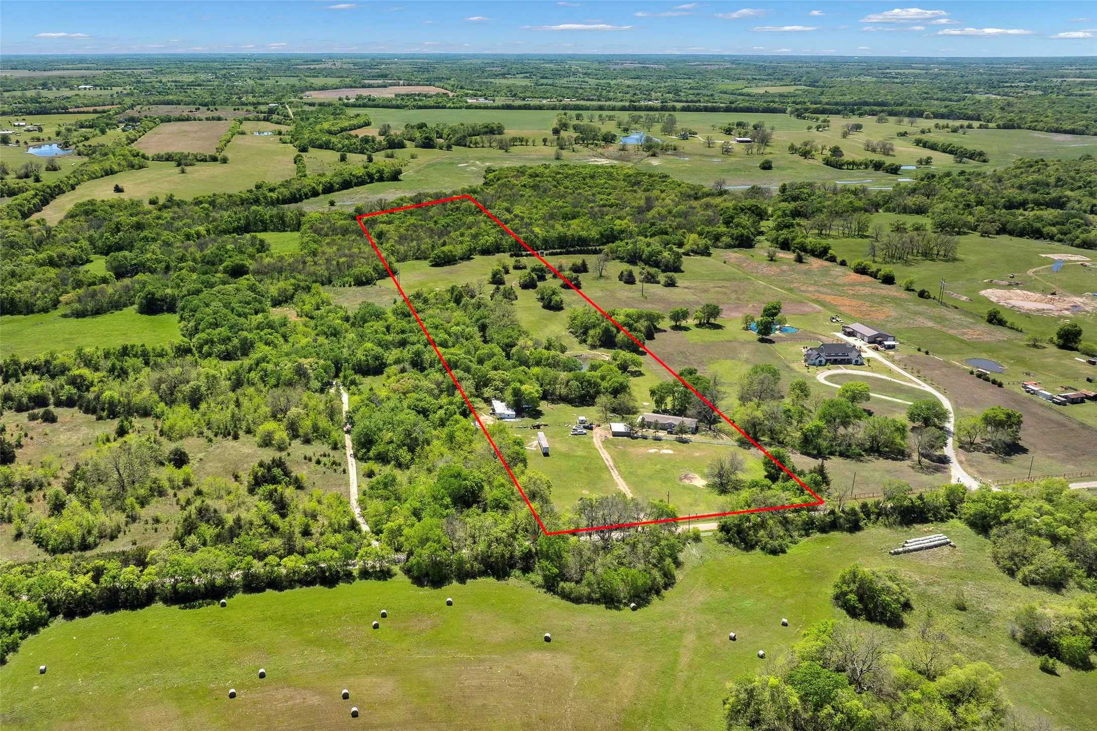 Expansive rural property featuring mature trees and open clearings