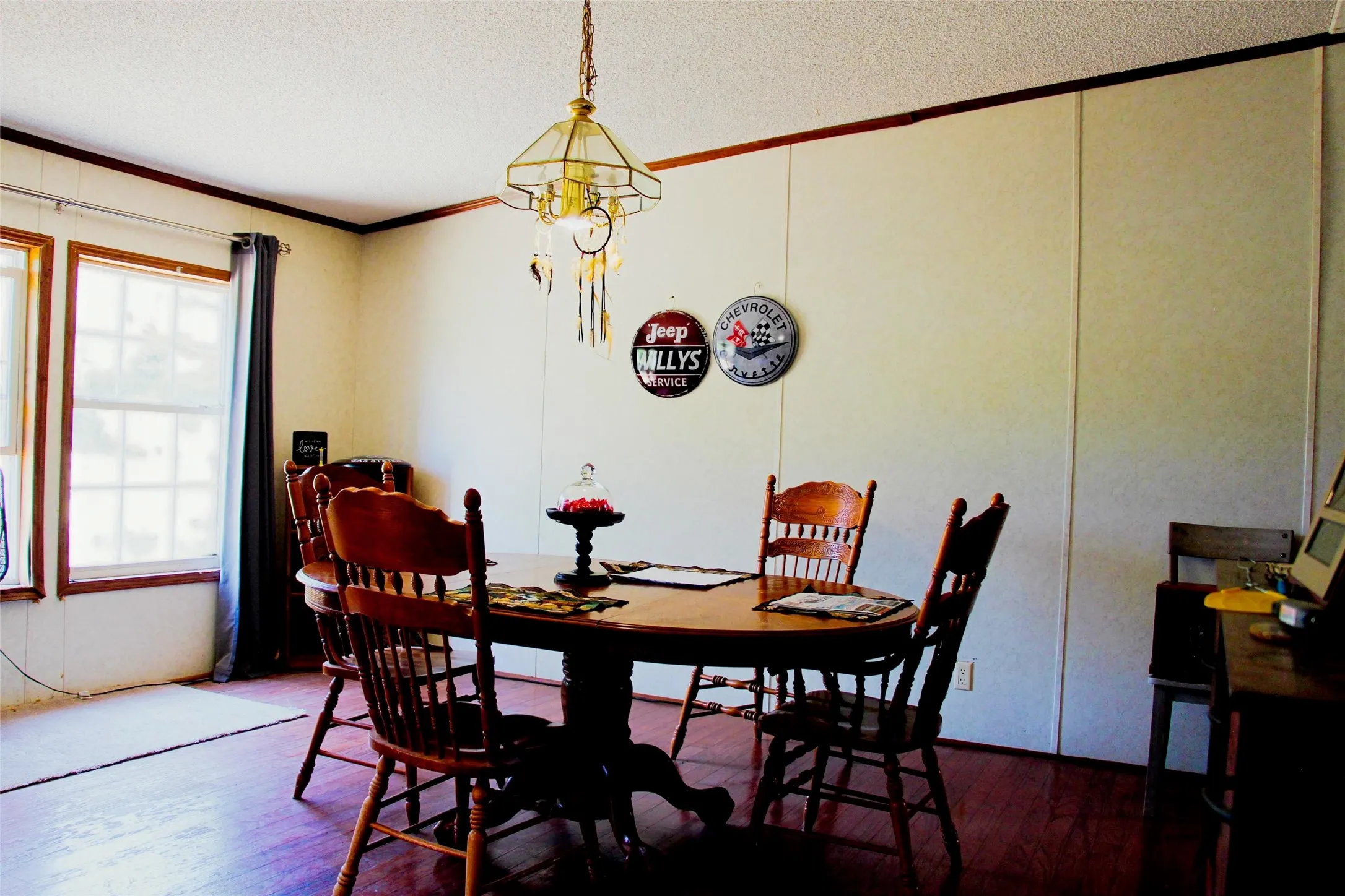 Dining area featuring wood-finish flooring, paneled walls, and multiple windows