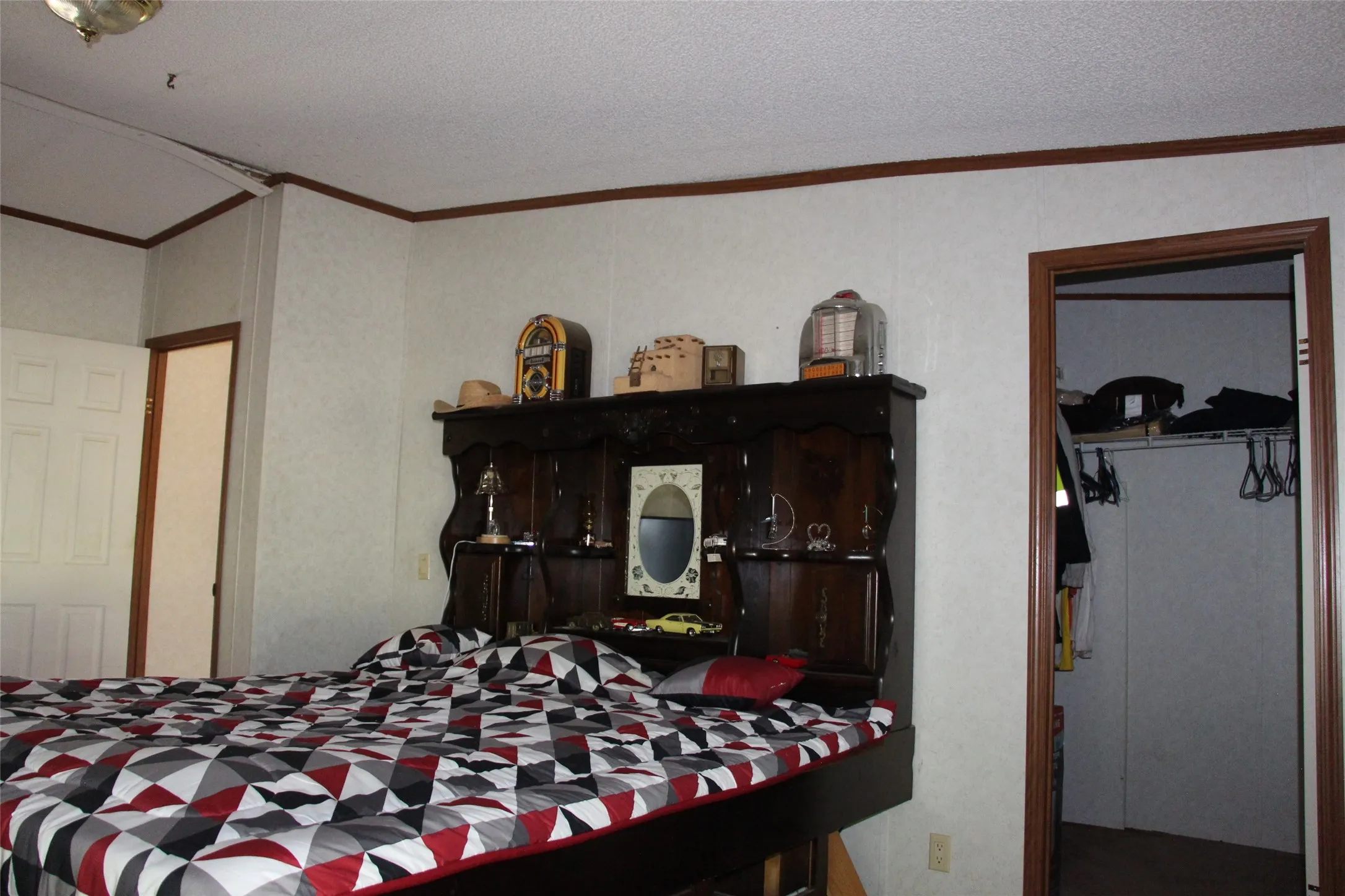 Bedroom with wood-finish trim, paneling, and an open closet featuring shelving and hanging space