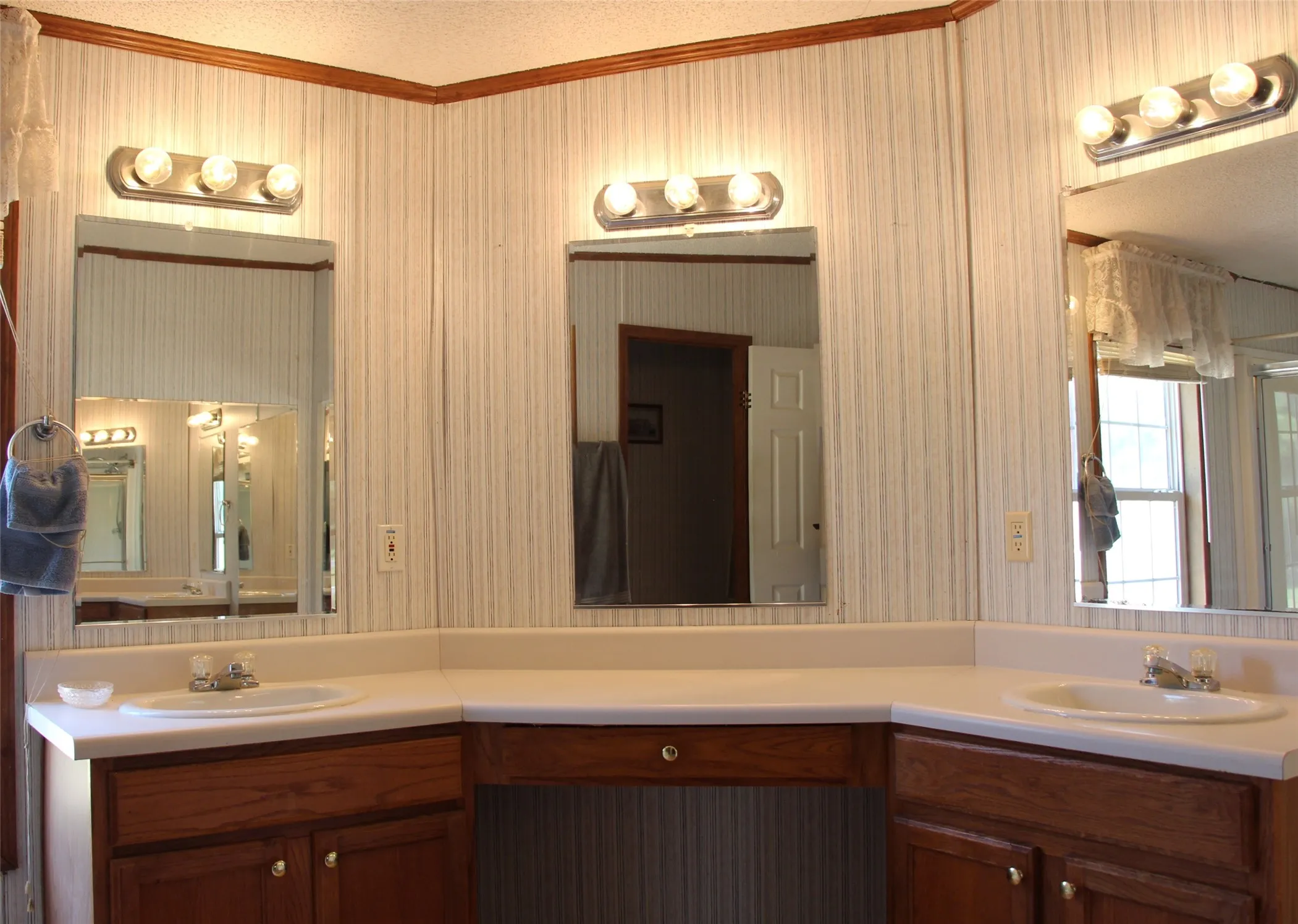 Double vanity with white countertops, integrated sinks, and wood-finish cabinetry