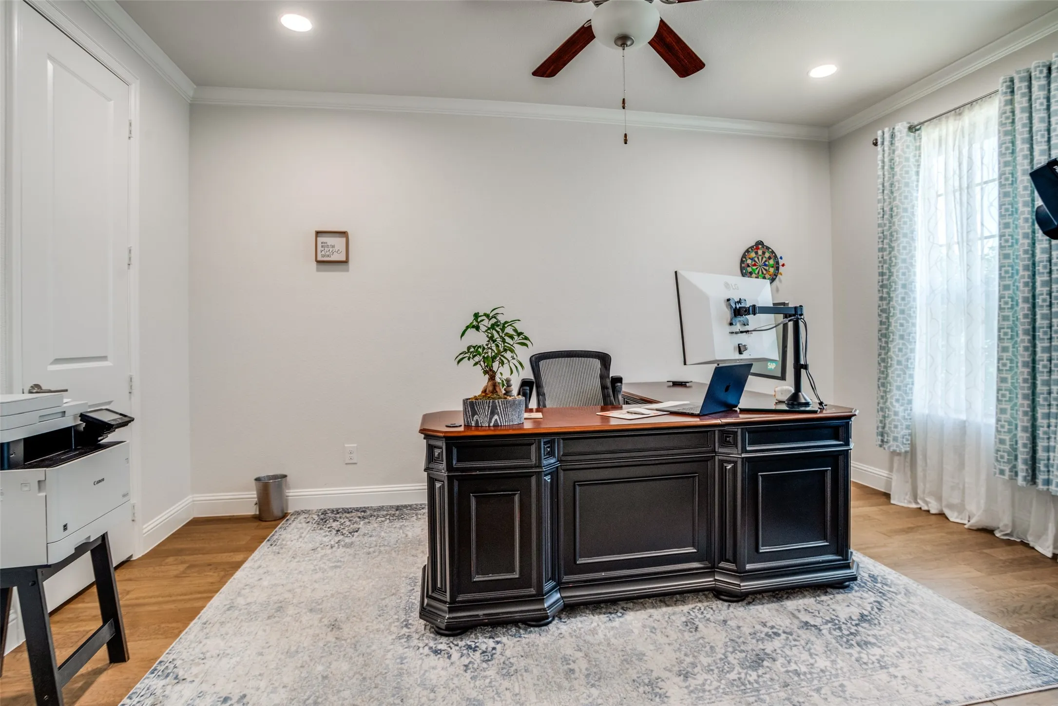 Spacious room featuring wood-finish flooring, recessed lighting, a ceiling fan, crown molding, and a window with white blinds and patterned curtains