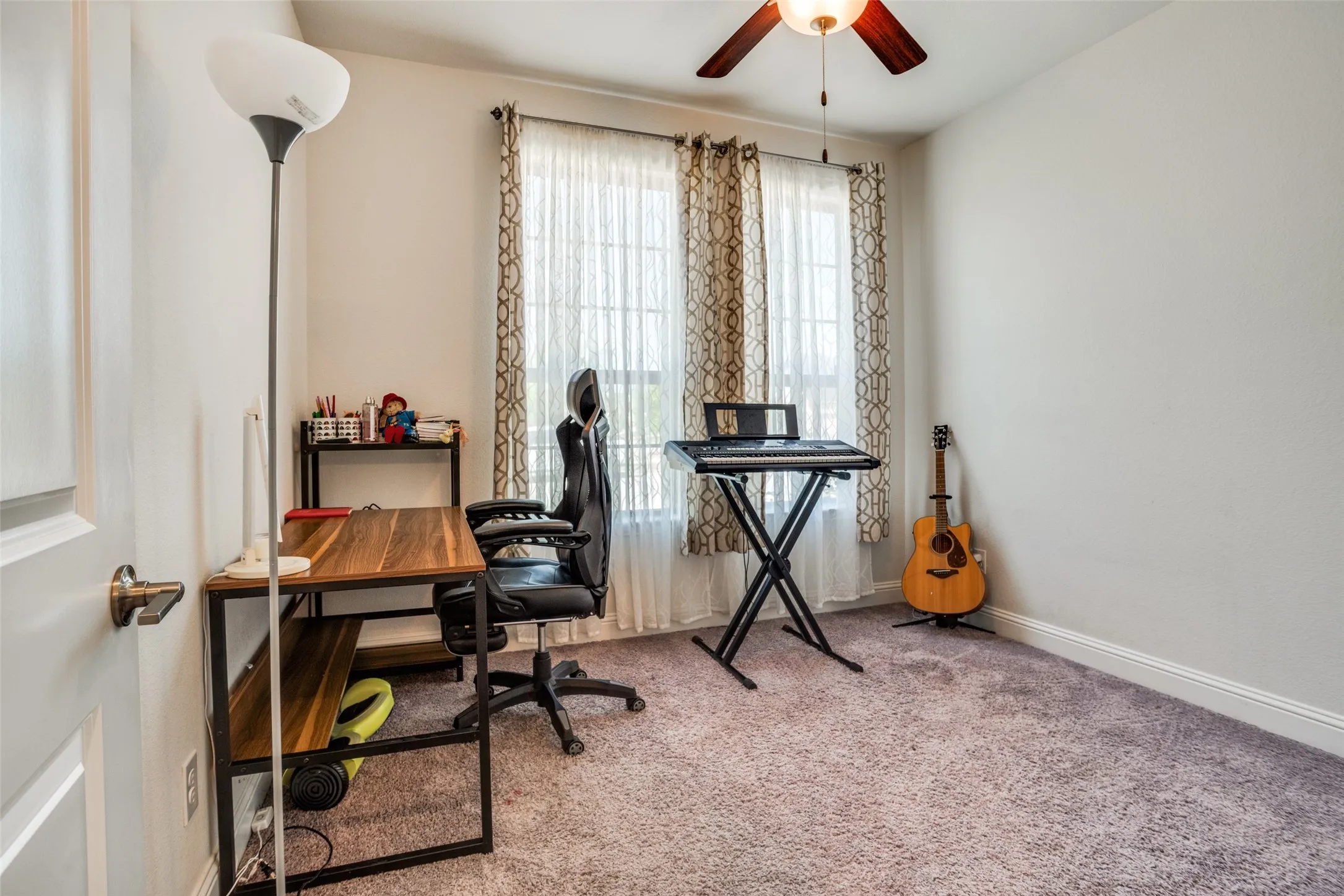 Room featuring light purple carpet flooring, white baseboards, and neutral wall paint