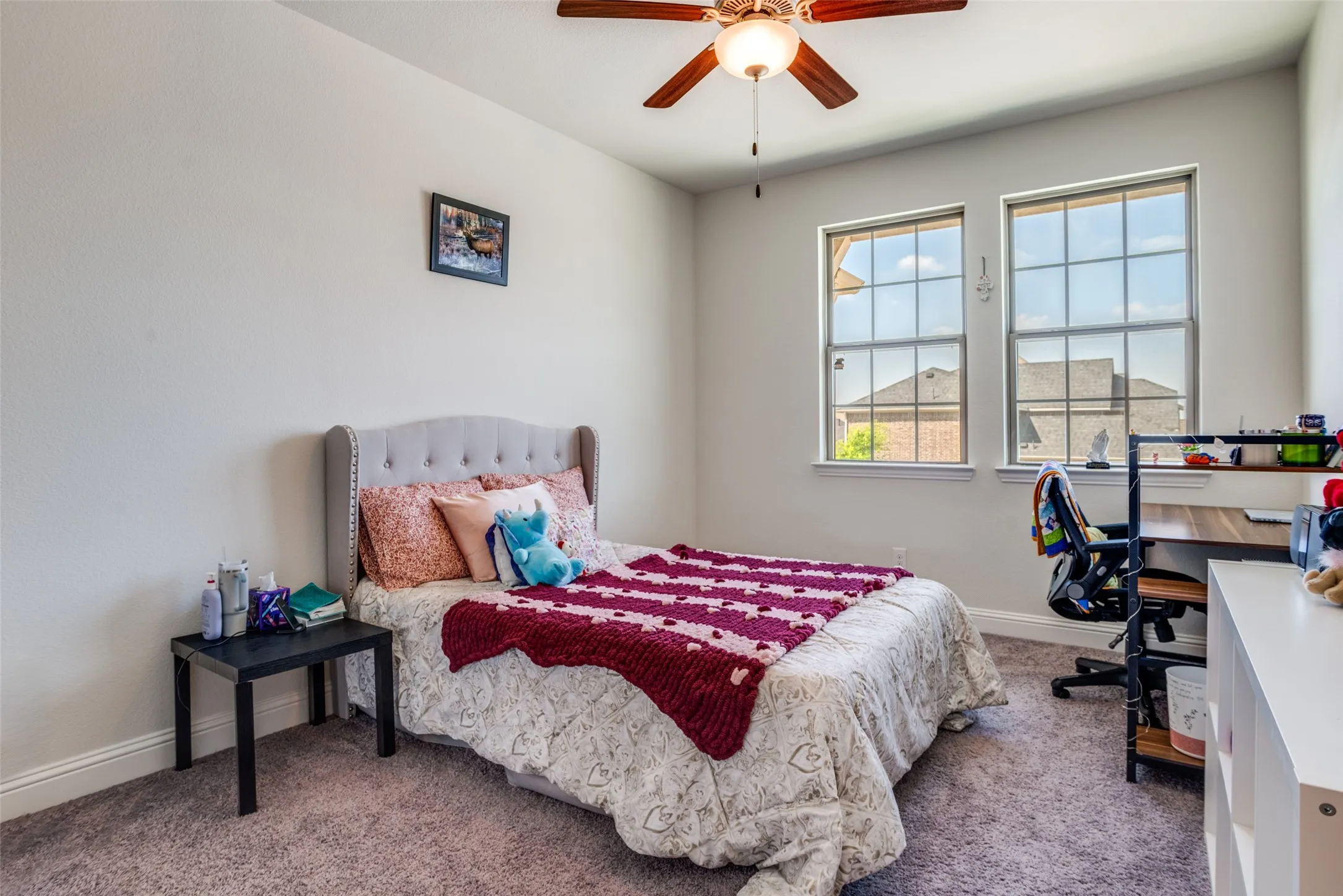 Carpeted room featuring two large windows with grid patterns