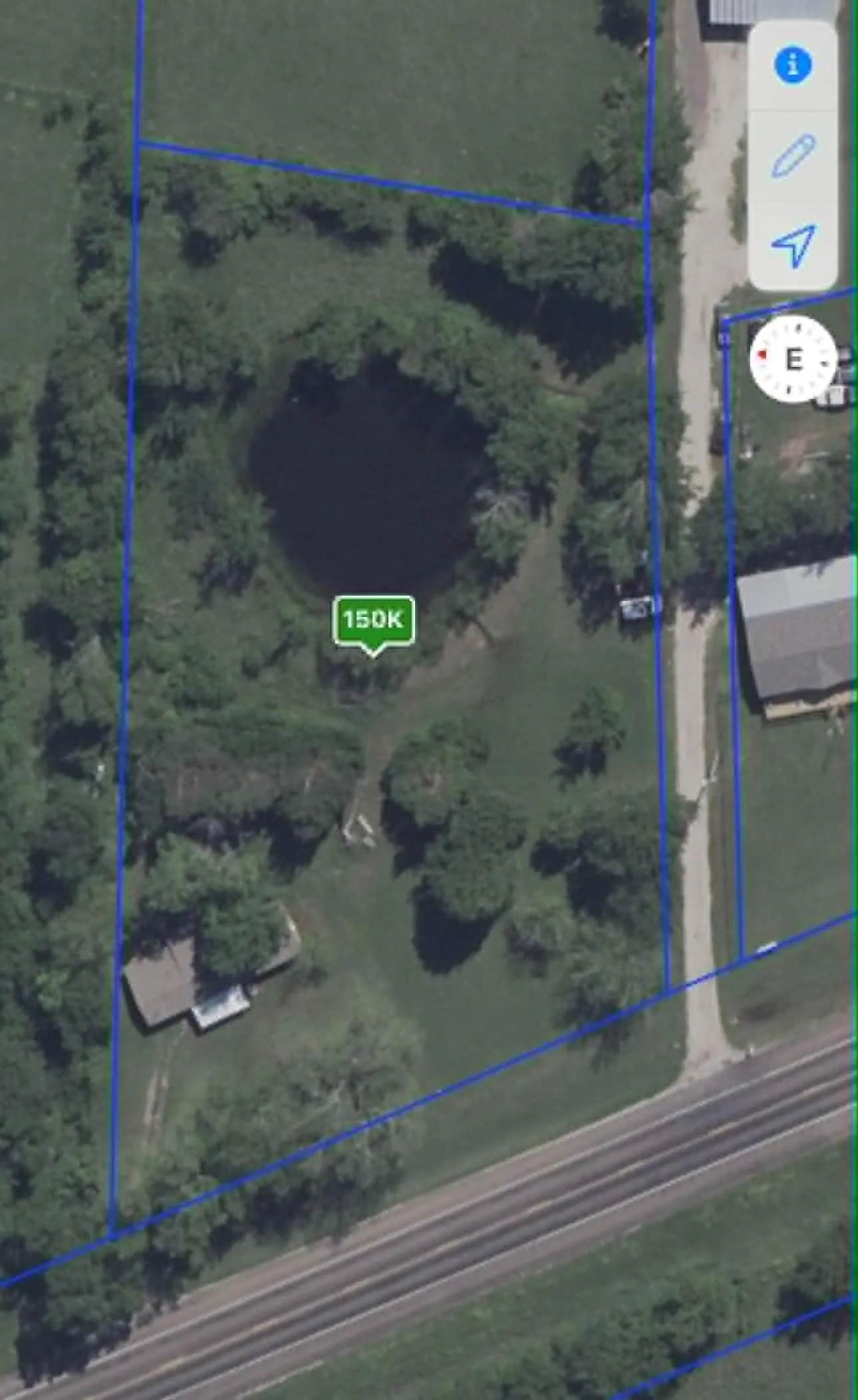 Aerial Property Map. Displaying the outline of the property with a pond and structures, indicating a value of 150K