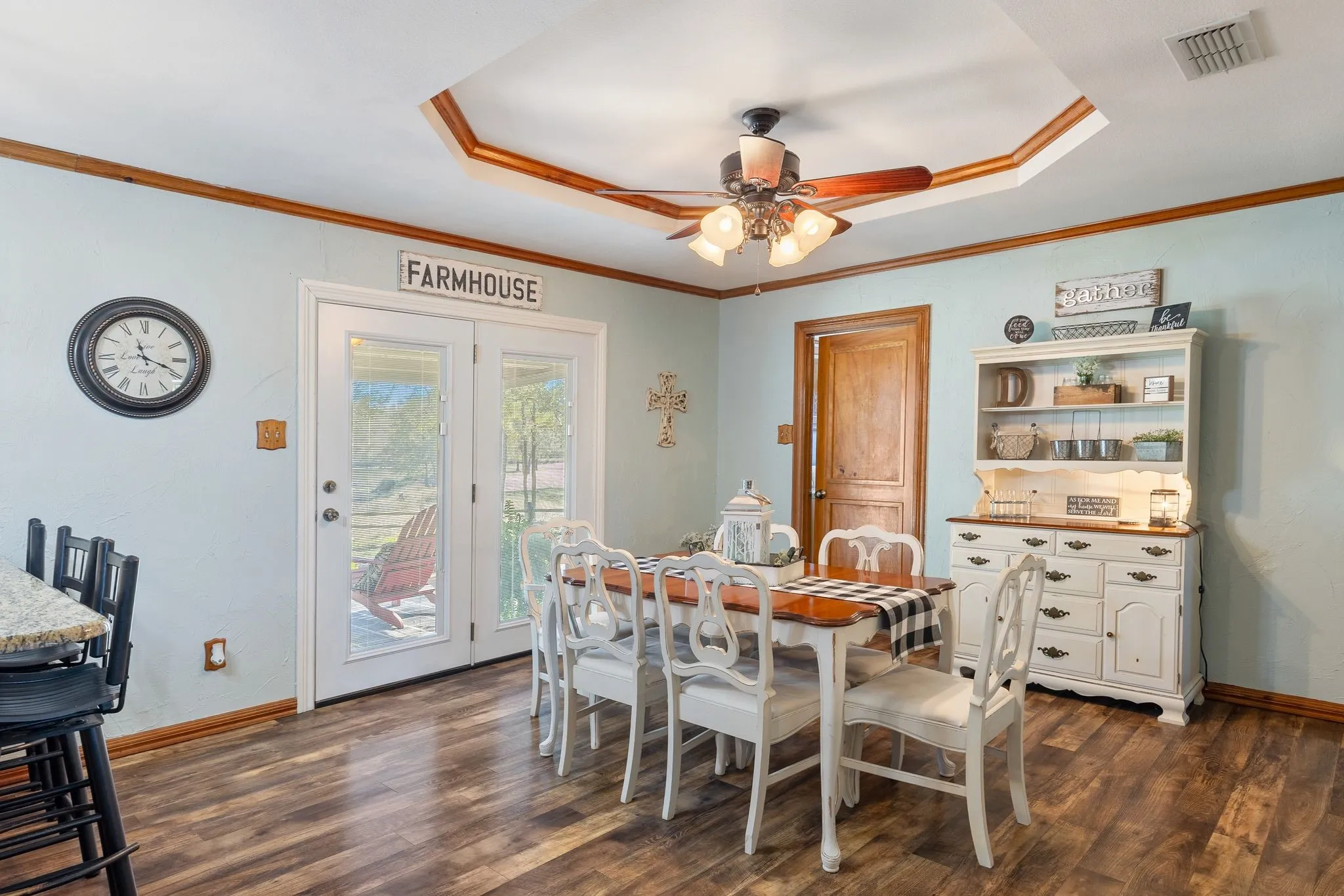 Dining room with ceiling fan, crown molding, a raised ceiling, and dark hardwood / wood-style flooring
