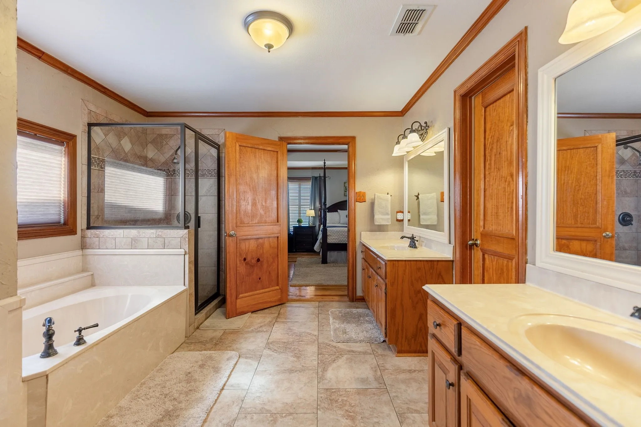 Bathroom featuring vanity, crown molding, and independent shower and bath