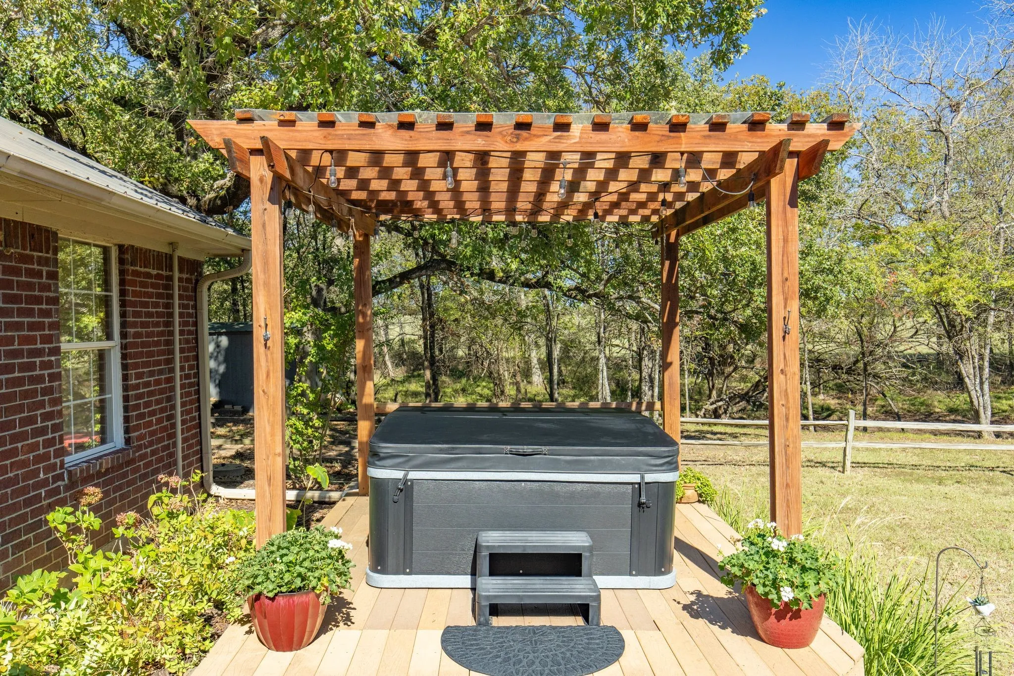 Wooden deck with a hot tub and a pergola